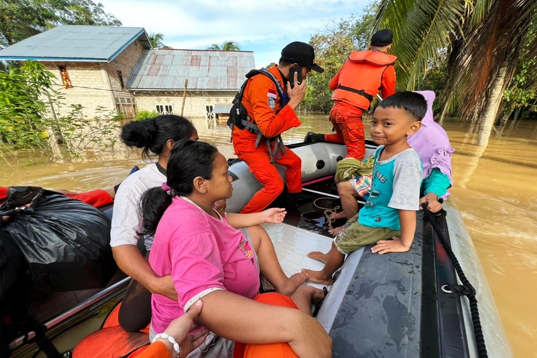 Tim SAR dari Basarnas Bungo mengevakuasi seorang ibu hamil berat dan anggota keluarganya dari lokasi banjir di Kabupaten Bungo.