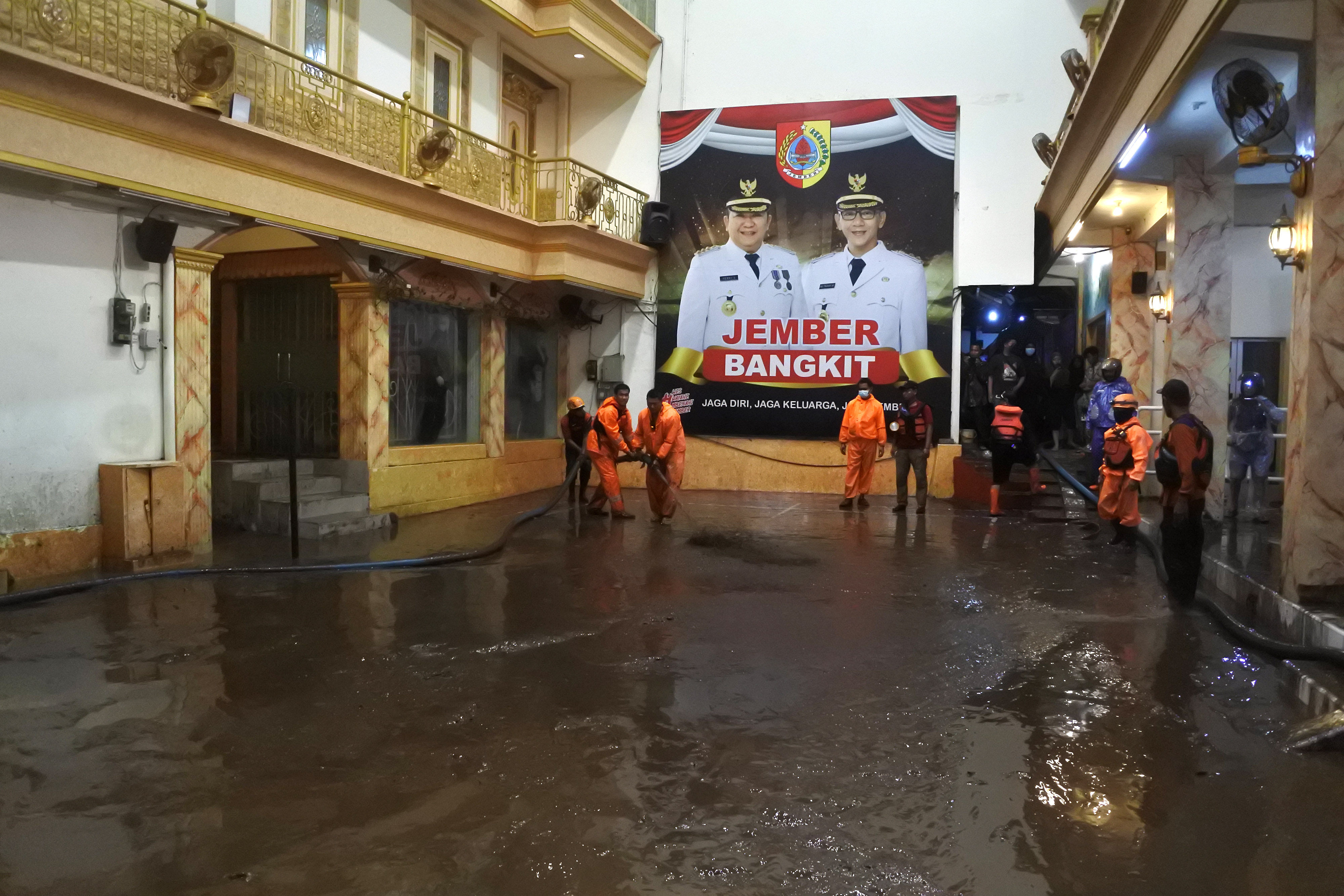 Petugas BPBD membersihkan lumpur usai banjir merendam rumah Bupati Jember Hendy Siswanto di Kecamatan Kaliwates, Jember, Senin (17/1/2022).
