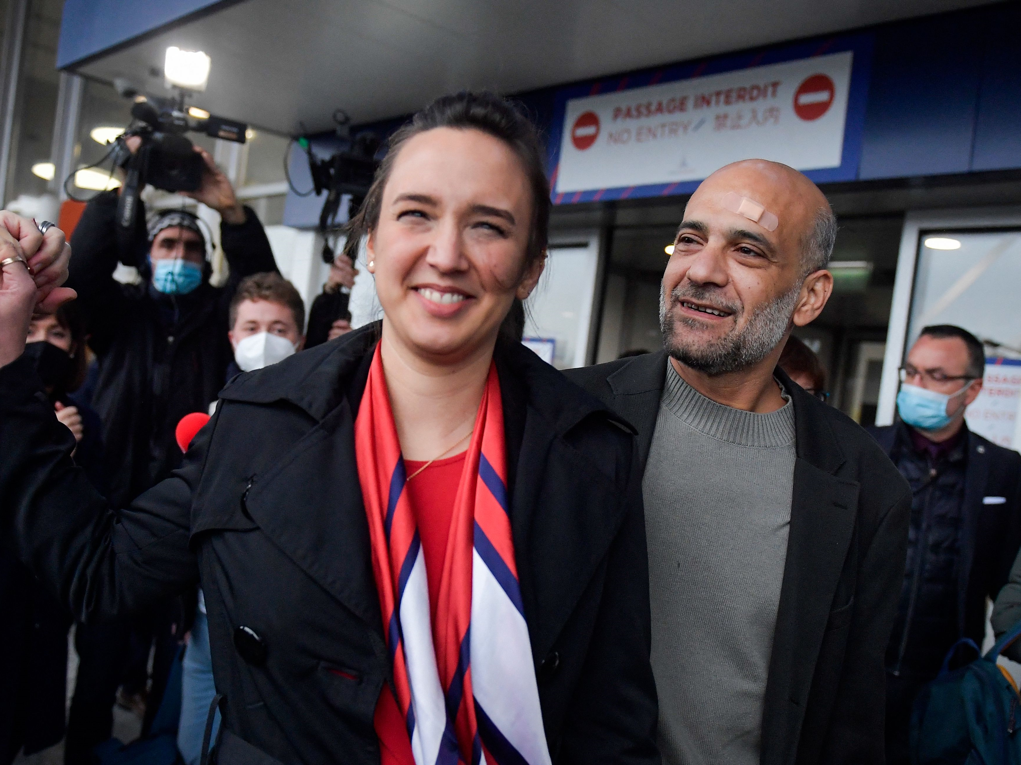 Aktivis politik Mesir-Palestina Ramy Shaath (kanan) menggandeng istrinya Celine Lebrun-Shaath saat dia meninggalkan bandara Roissy, Prancis.