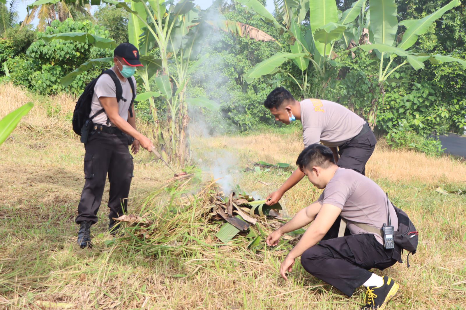 Anggota Polres Badung membersihkan lahan yang akan dipakai dalam program 'Polisi Berkebun'.
