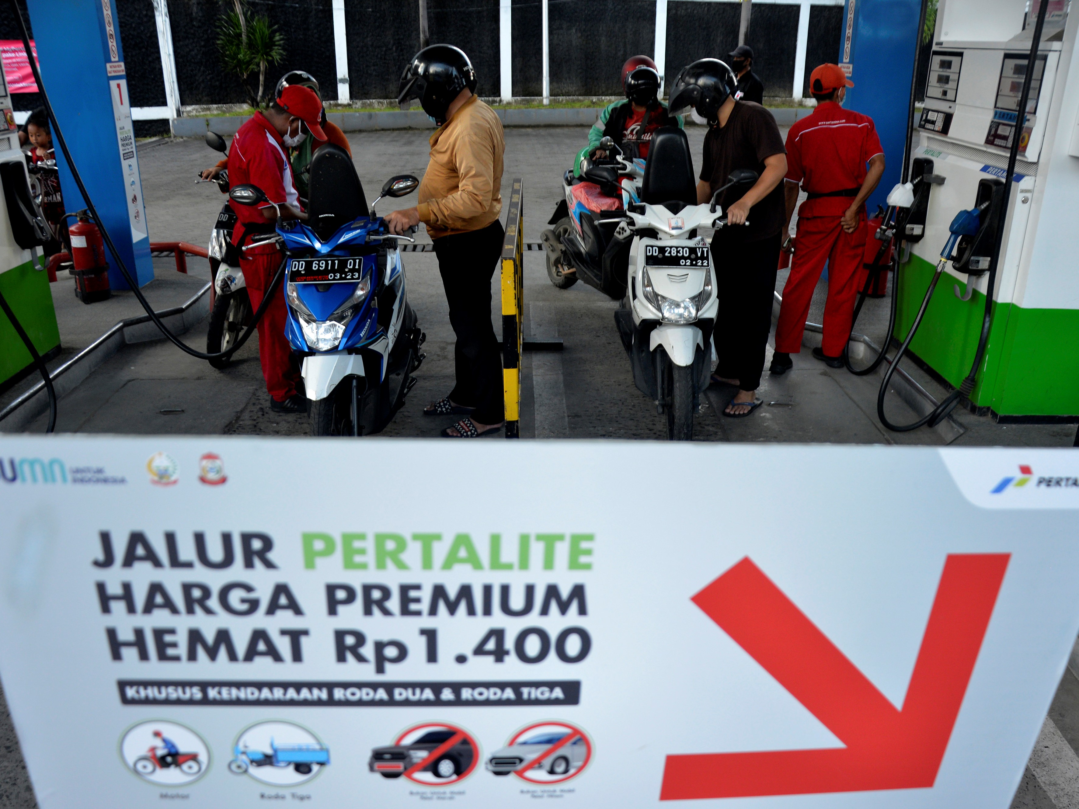 Karyawan SPBU melakukan pengisian BBM jenis Pertalite ke tangki sepeda motor saat promo Langit Biru Pertamina di Makassar, Sulawesi Selatan.