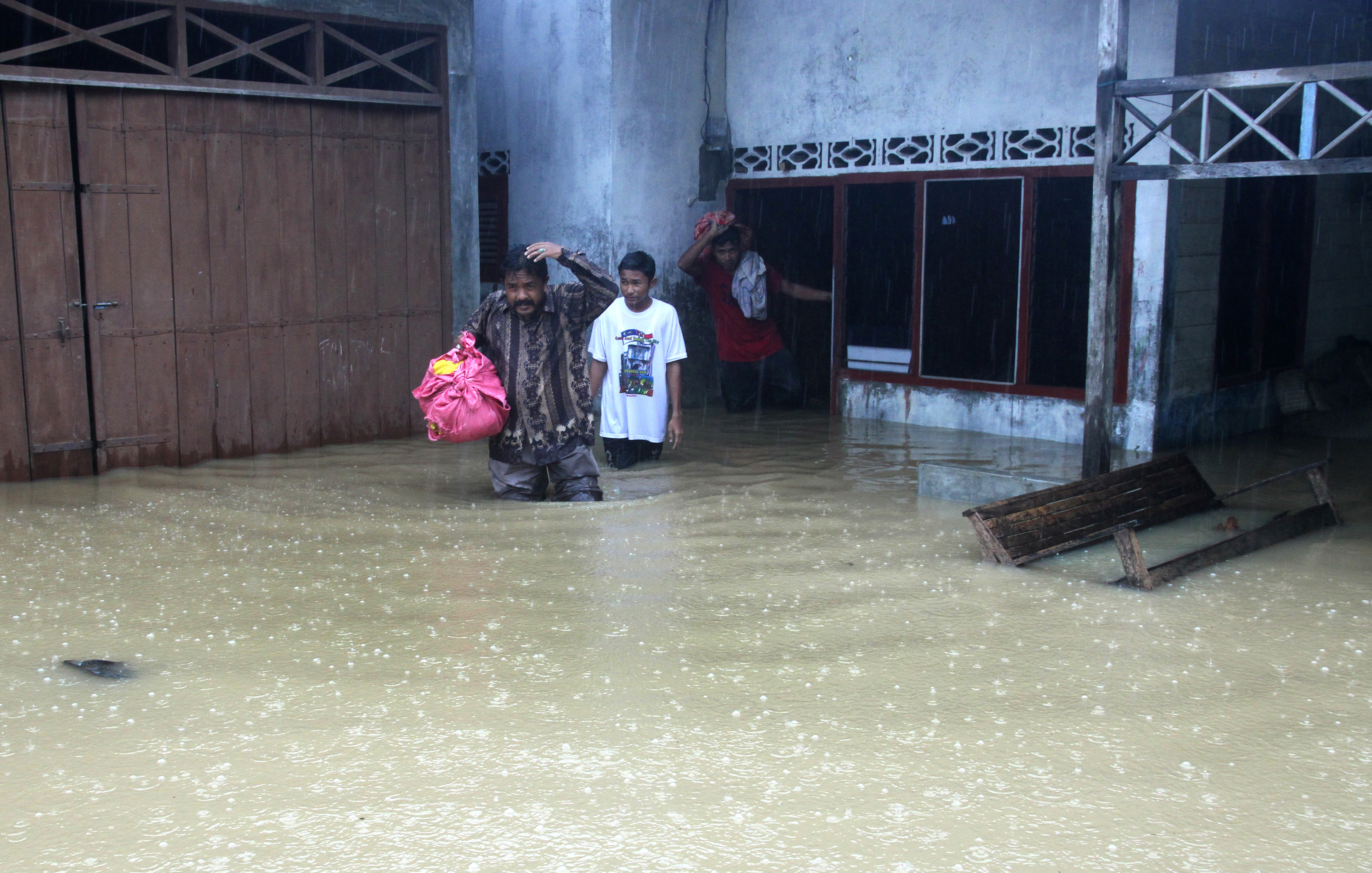 BANJIR: Sejumlah warga mengevakuasi barang-barang miliknya dari genangan banjir di Desa Teupin Bate, Aceh Timur, Aceh.