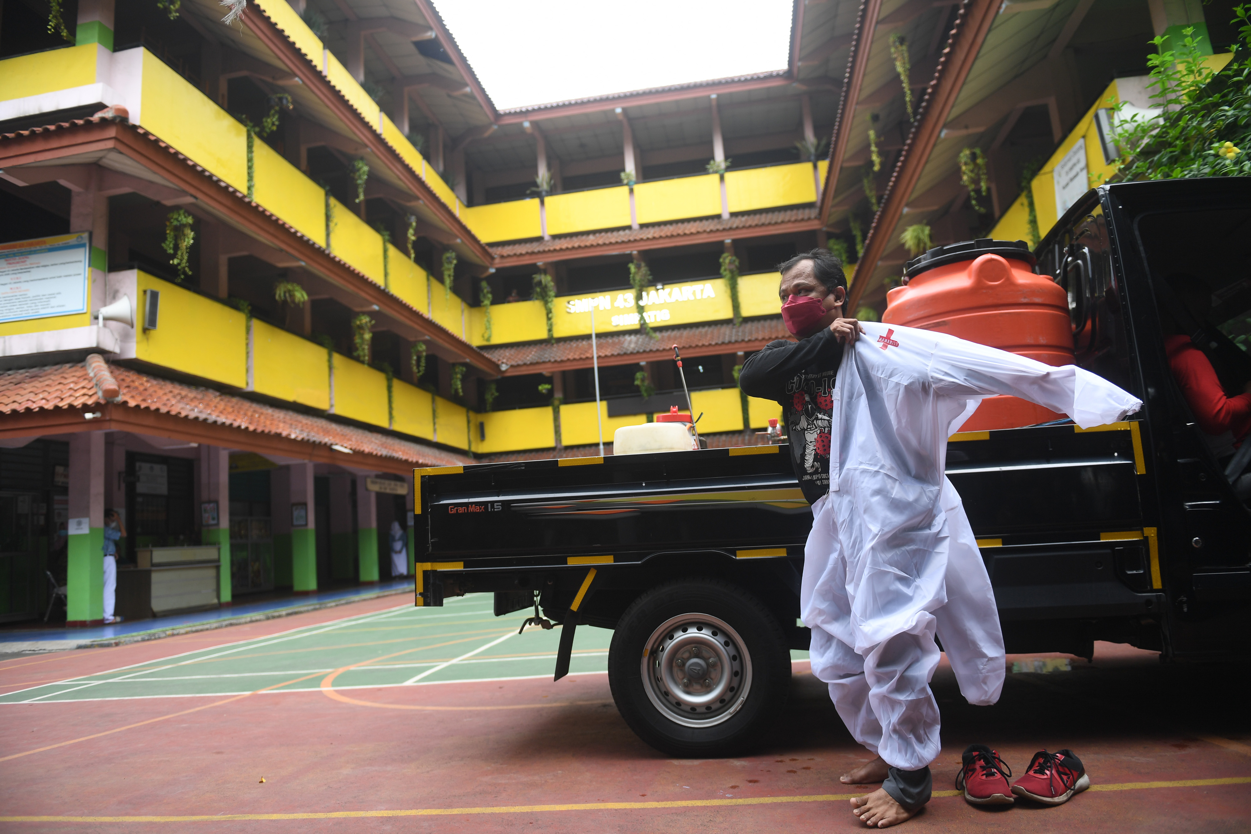 Petugas kesehatan bersiap menyemprotakn disinfektan di sekolah yang ditemukan kasus Covid-19