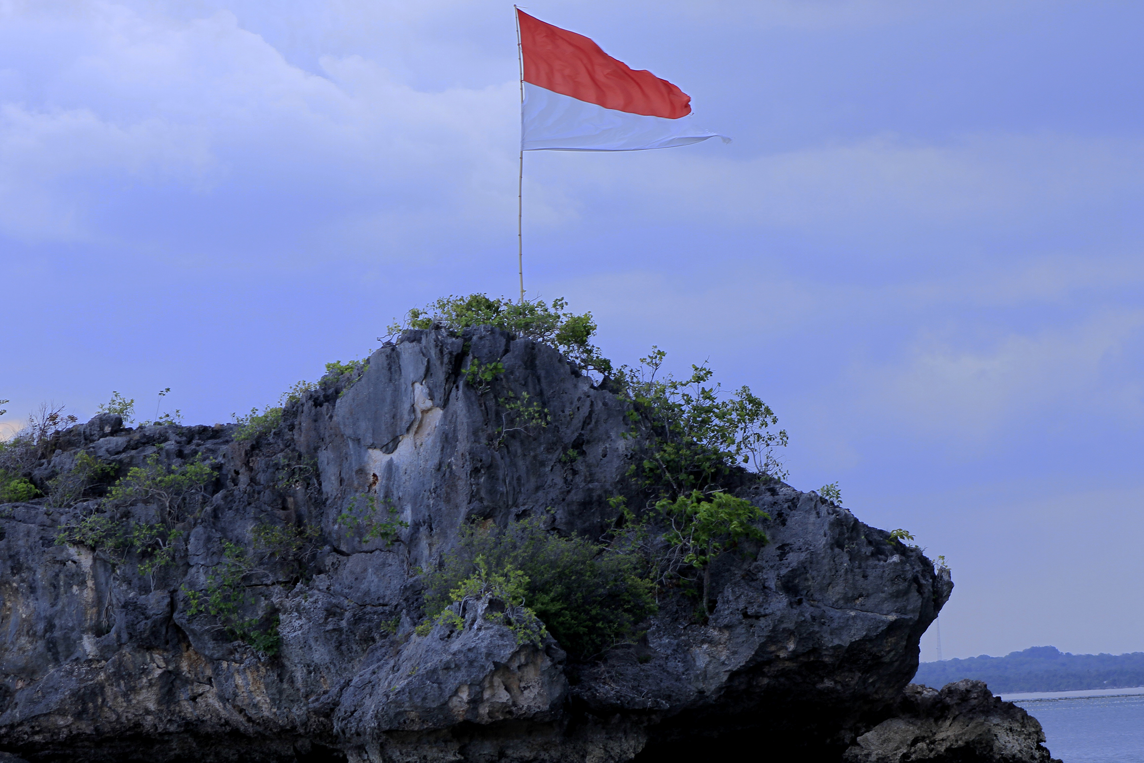 Bendera Merah Putih berkibar di salah satu pulau kecil yang berada di dekat Kampung Merah Putih di Desa Oeseli, Kabupaten Rote Ndao, NTT.