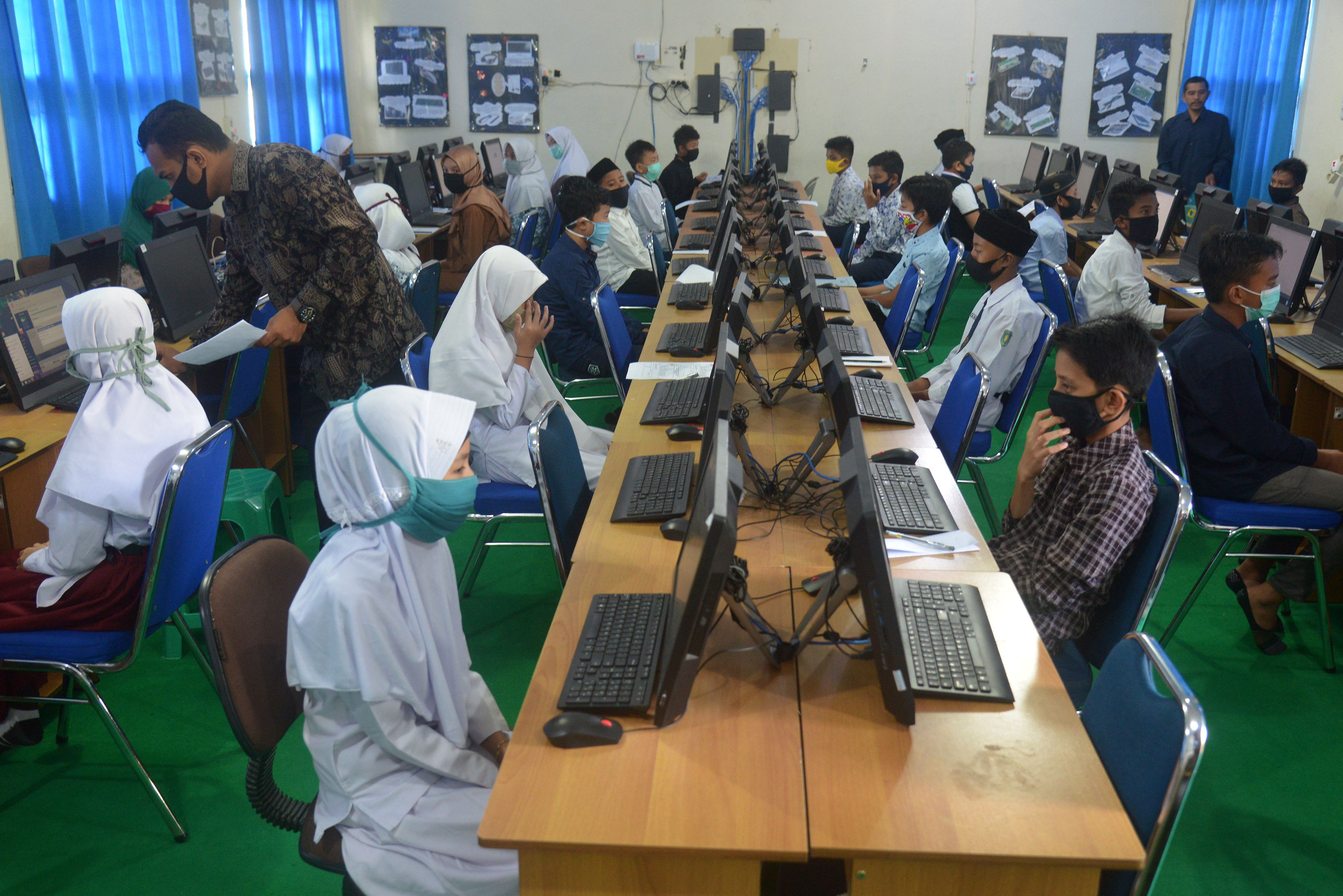 UJIAN: Sejumlah murid Sekolah Ibtidaiyah Negeri (MIN) mengikuti ujian berbasis komputer saat tes penerimaan MTsN di Banda Aceh, Aceh.