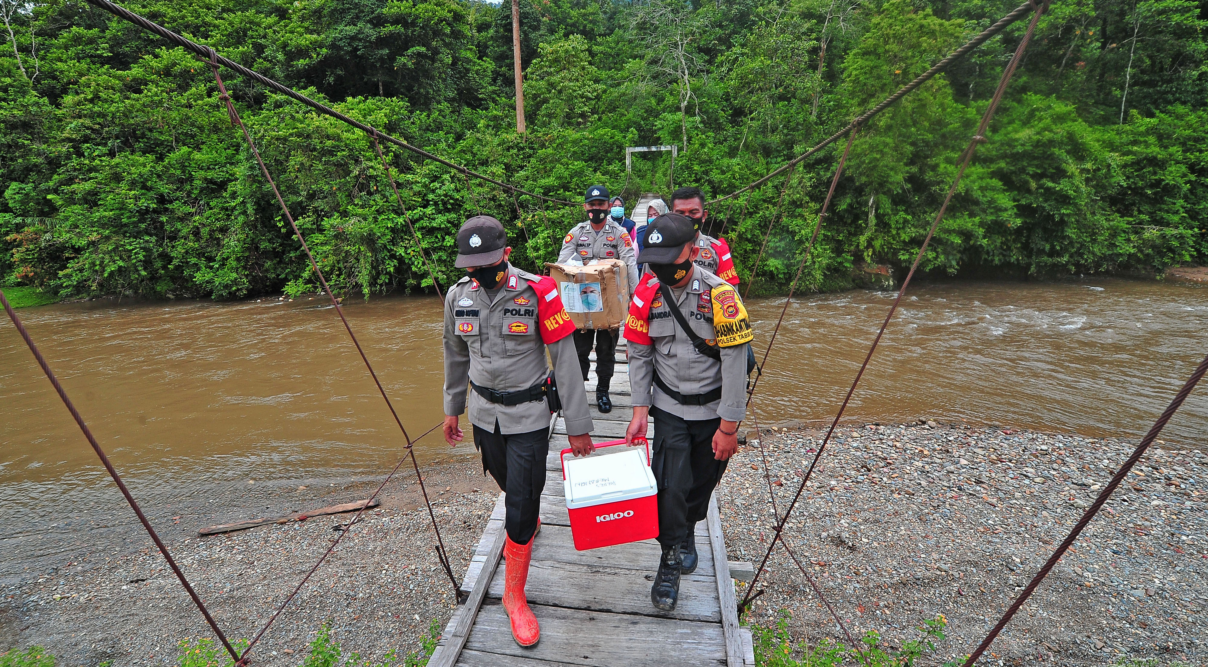 Petugas kepolisian mengantar vaksin ke desa terpencil di Provinsi Jambi, Minggu (10/10/2021). 