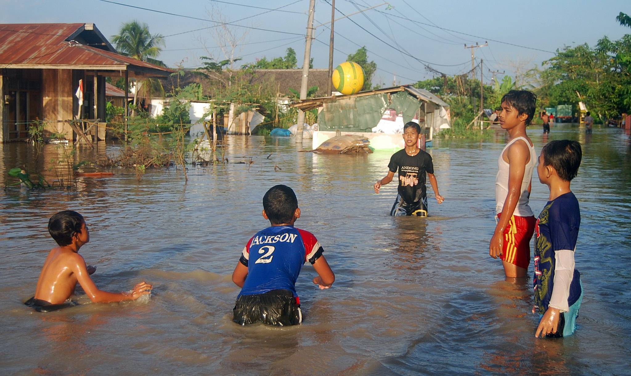 Beberapa anak tengah bermain ditengah banjir yang melanda sejumlah wilayah di Kutai Kartanegara, Kalimantan Timur.