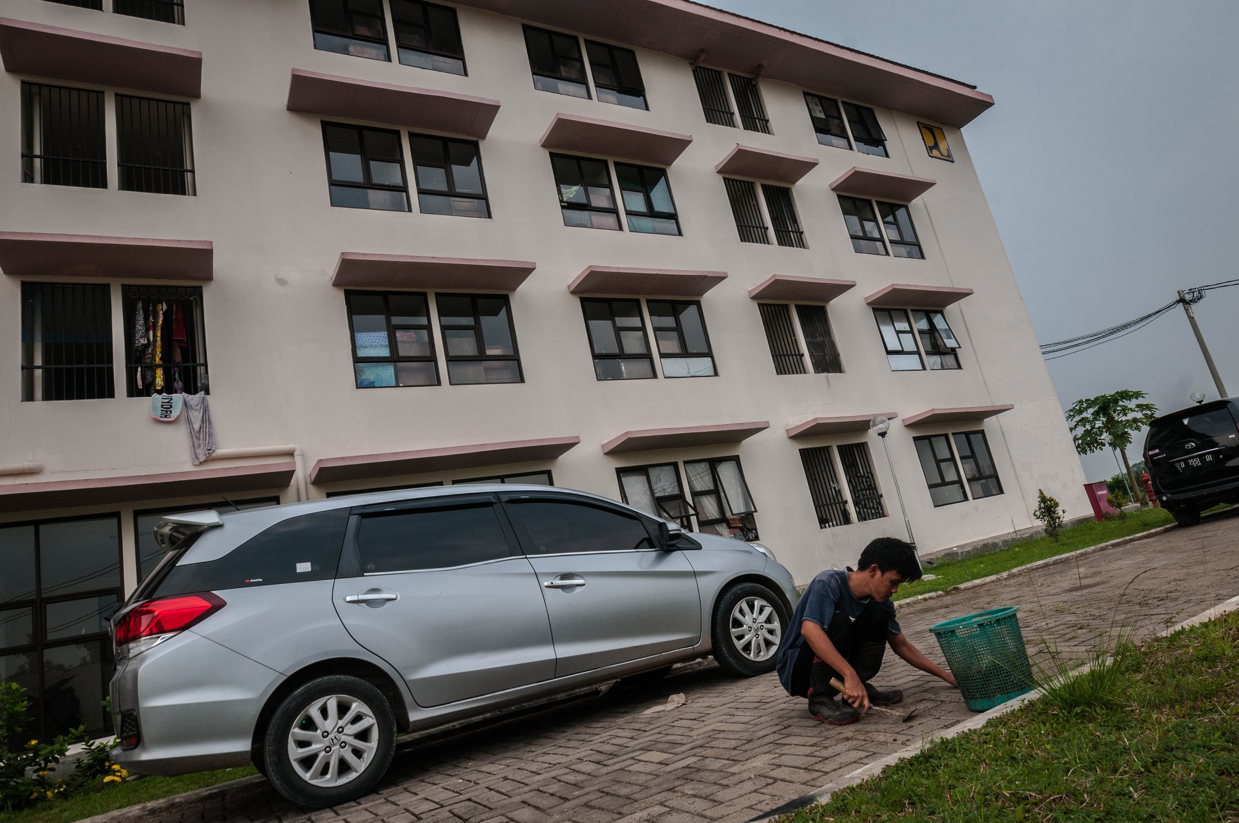 Pekerja memberishkan rumput di halaman Rusunawa Rangkasbitung, Lebak