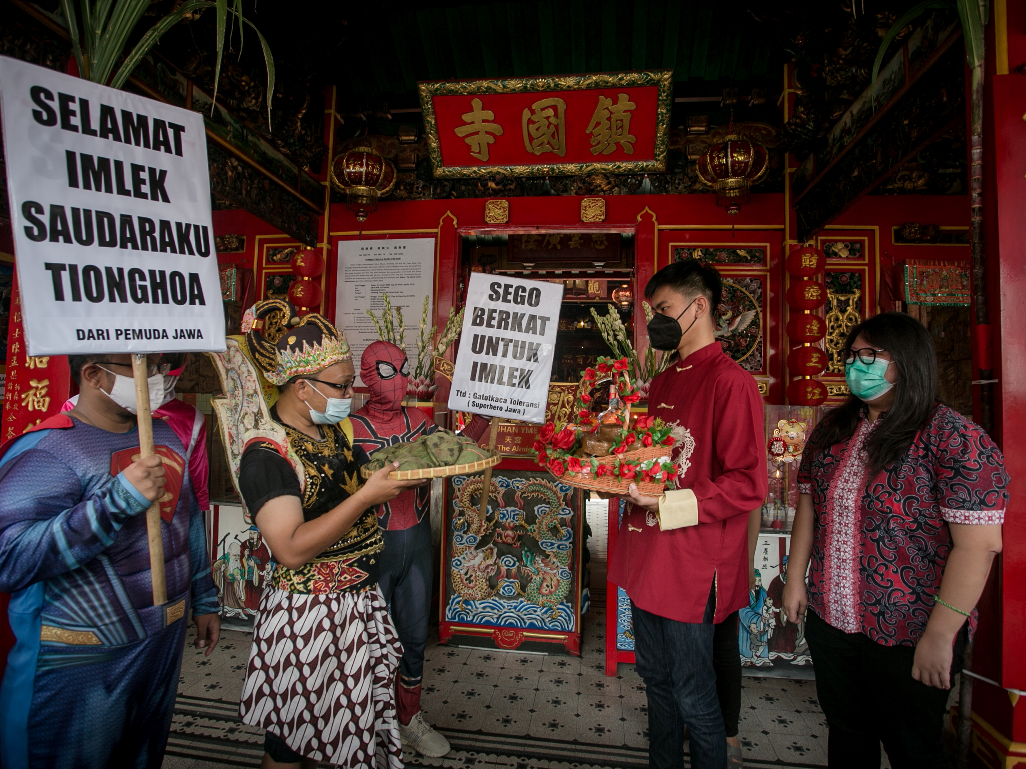 Warga dengan mengenakan kostum pewayangan dan superhero bertukar nasi berkat dengan kue keranjang di Klenteng Tien Kok Sie, Solo, Jateng.