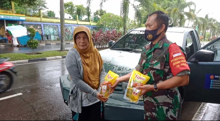 Seorang anggota TNI di Jambi membagikan minyak goreng gratis