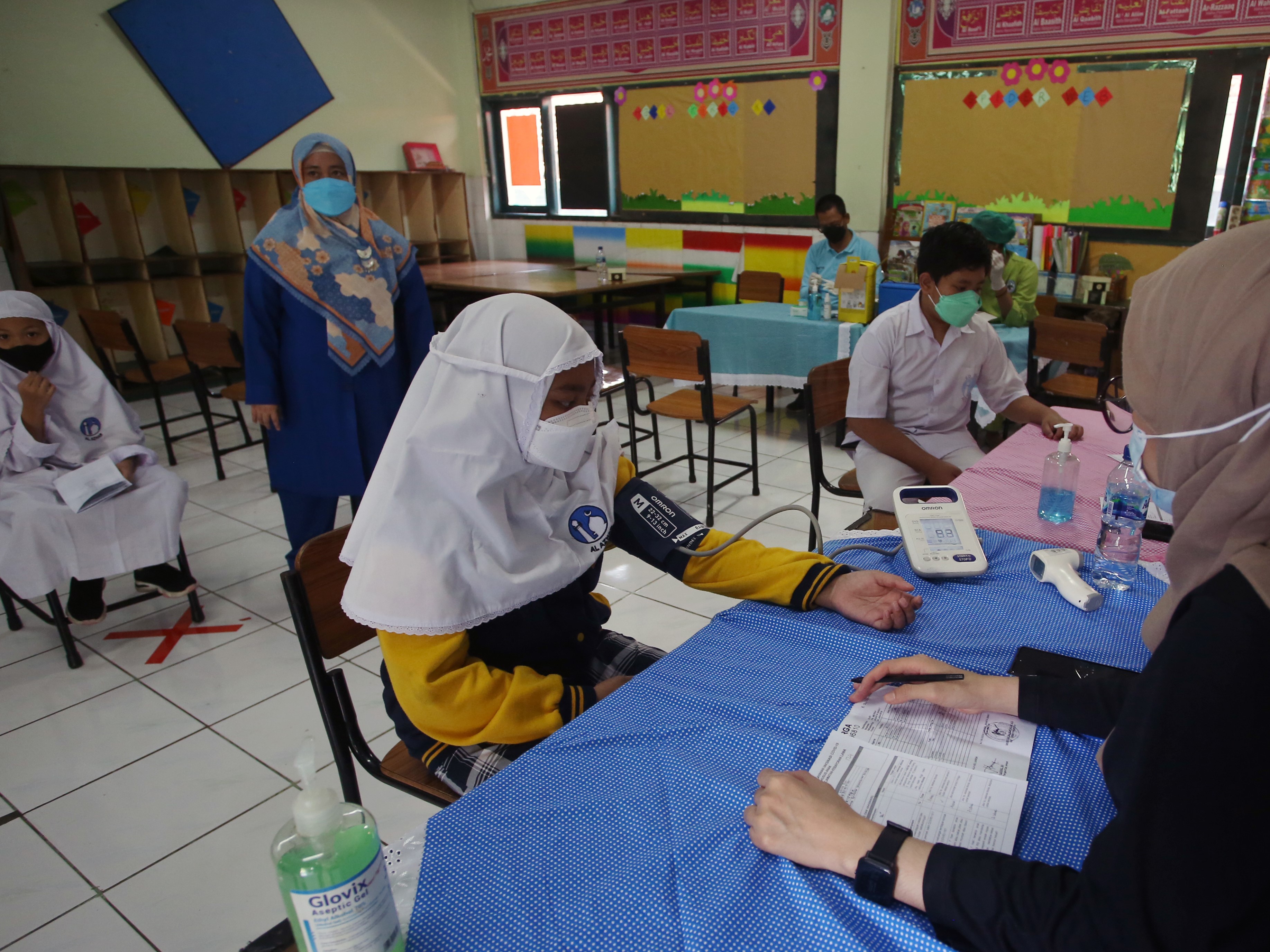 Tenaga kesehatan memeriksa kesehatan para murid yang akan disuntik vaksin covid-19 di SDI Al Azhar 5 Kebayoran Lama, Jakarta, Senin (3/1).