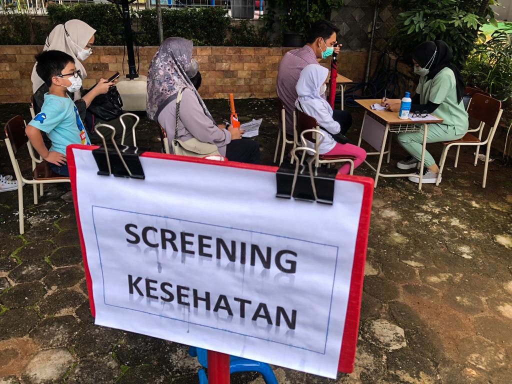  VAKSINASI ANAK: Petugas medis mendata kesehatan anak-anak yang didampingi orangtua saat mengikuti vaksinasi di Jakarta, Senin (17/1)