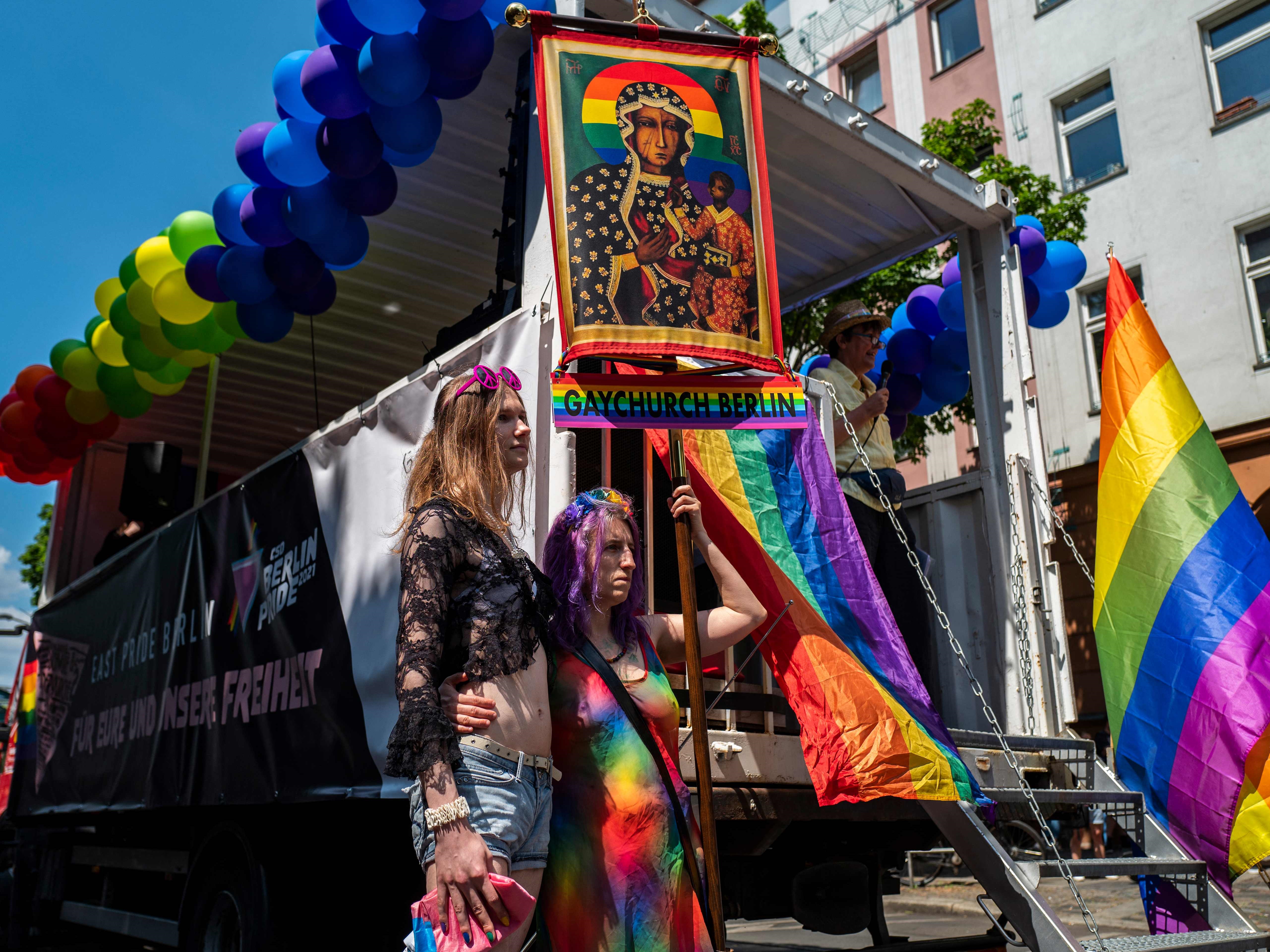 Para demonstran mengambil bagian dalam pawai LGBTQ dan menampilkan spanduk Gereja Gay Berlin di Berlin, 6 Juni 2021.