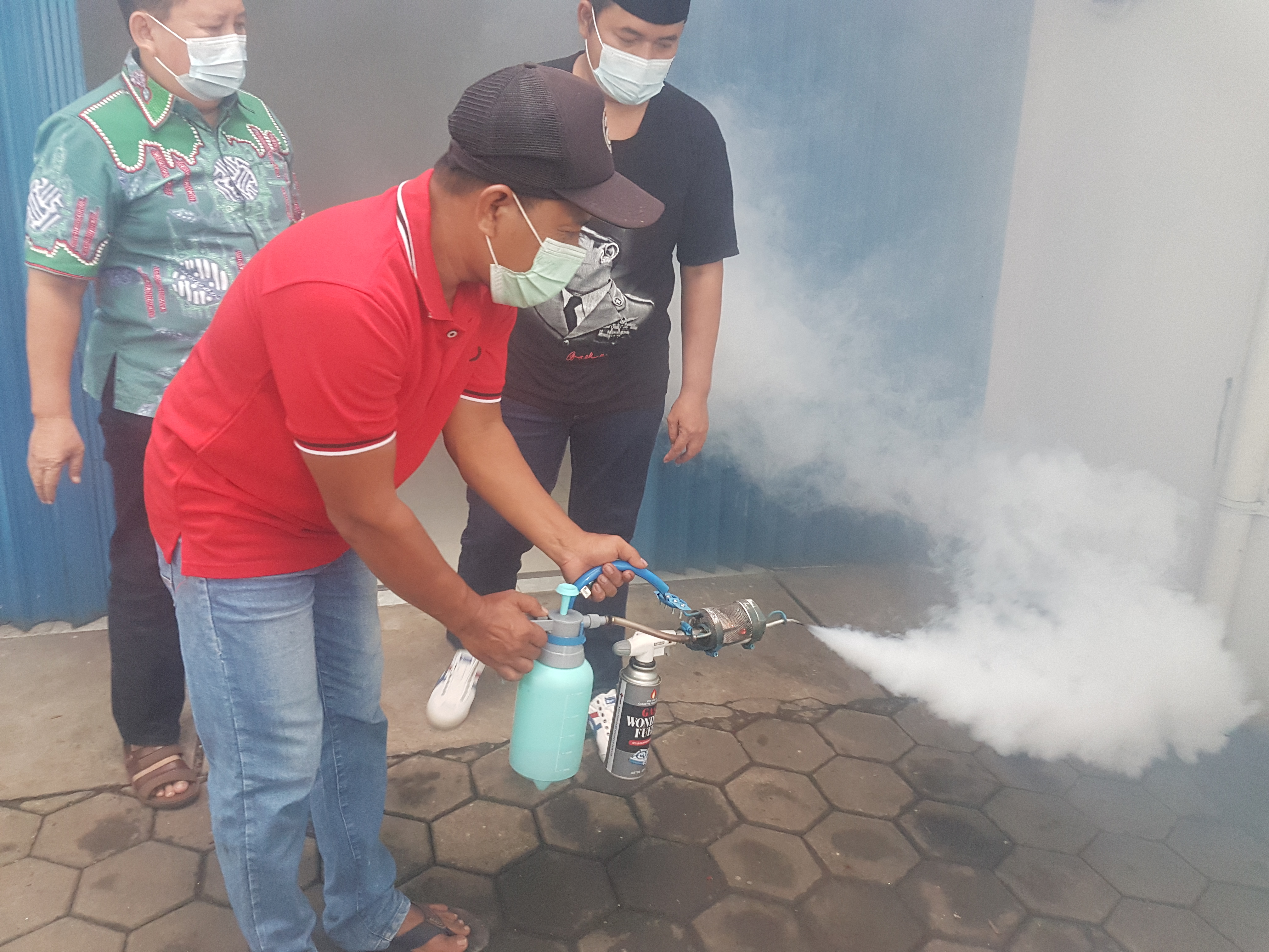 Heru Rusiyanto (kaos merah) menunjukkan cara kerja fogging mini rakitannya, Selasa (11/1)