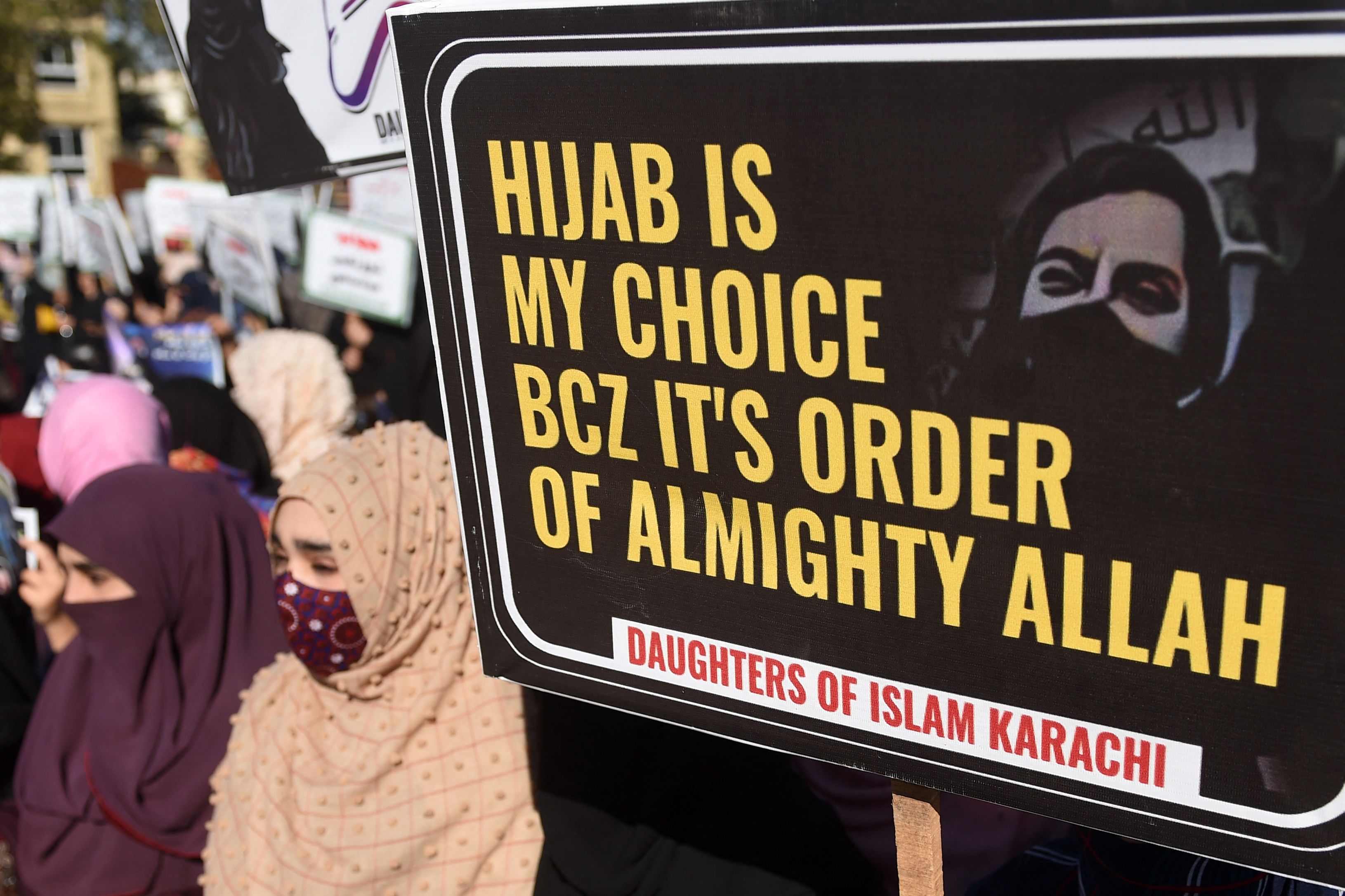 Aktivis dan pendukung dari Daughters of Islam Karachi, memegang spanduk saat mereka mengambil bagian dalam demonstrasi di Karachi, 13 Februa