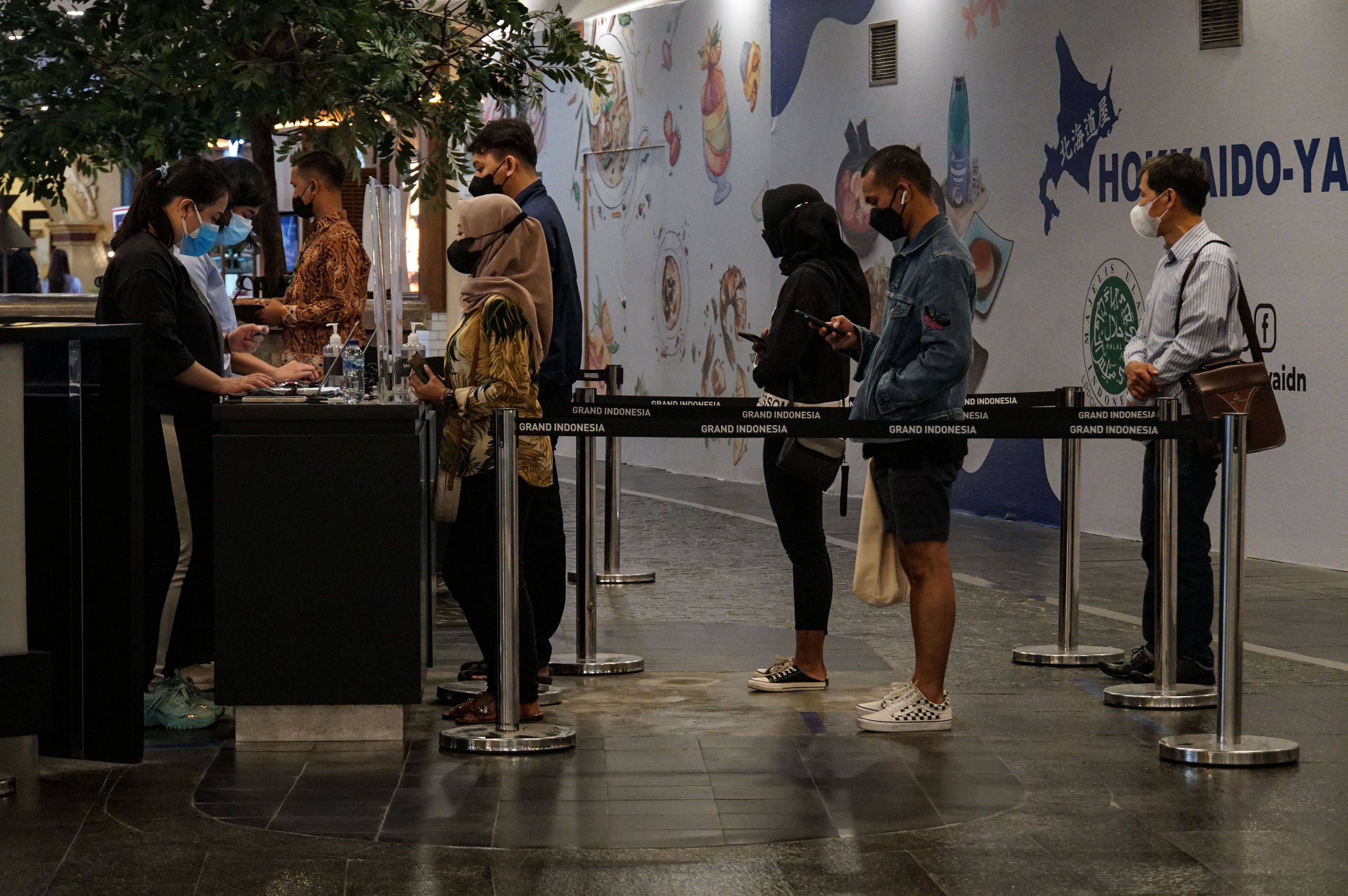 Warga antre untuk mengikuti vaksinasi covid-19 dosis ketiga di Grand Indonesia, Jakarta, Senin (14/2).