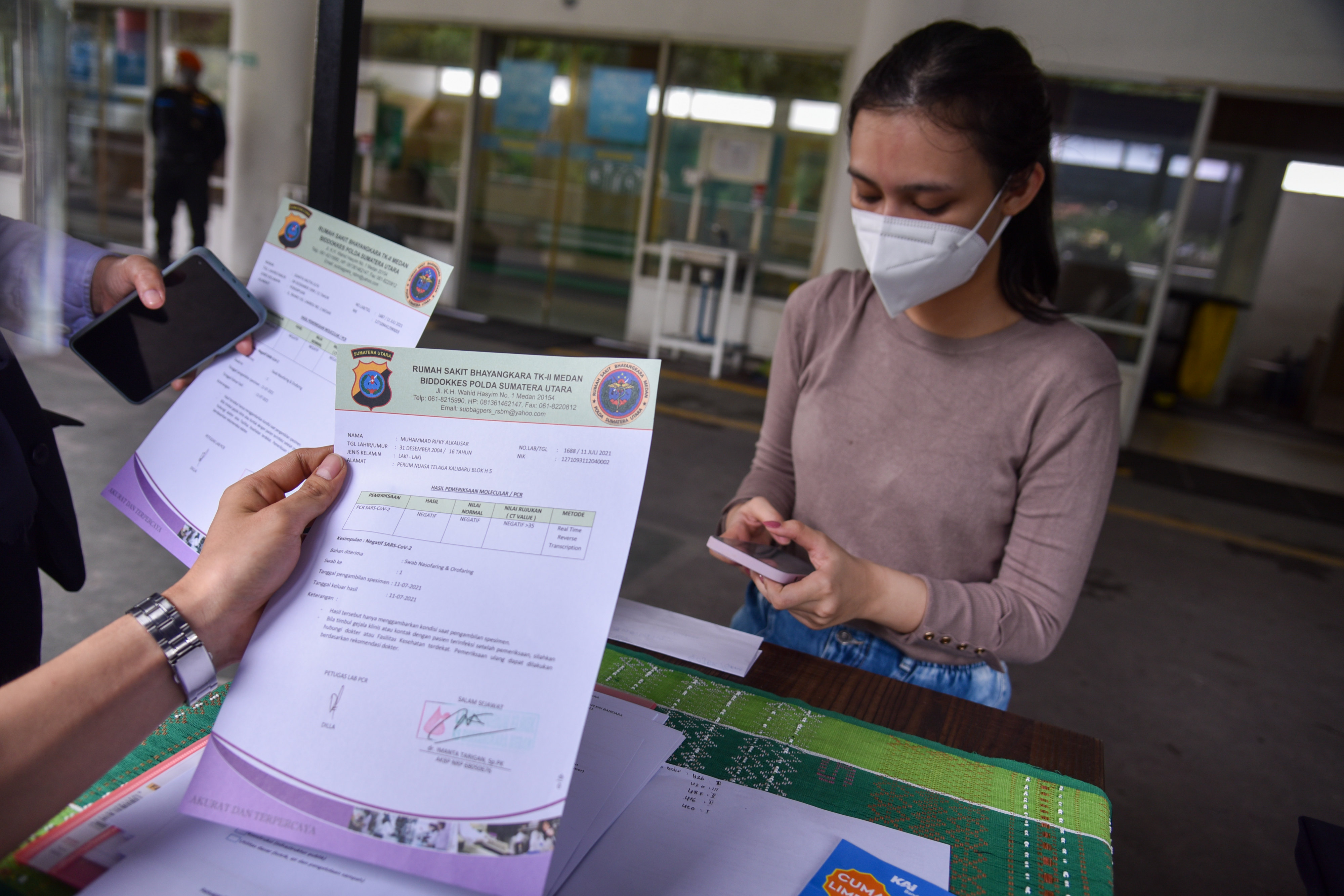 Petugas melayani warga untuk pengecekan dokumen surat keterangan bebas covid-19 di Stasiun Kereta Api Medan, Kota Medan, Sumatra Utara.
