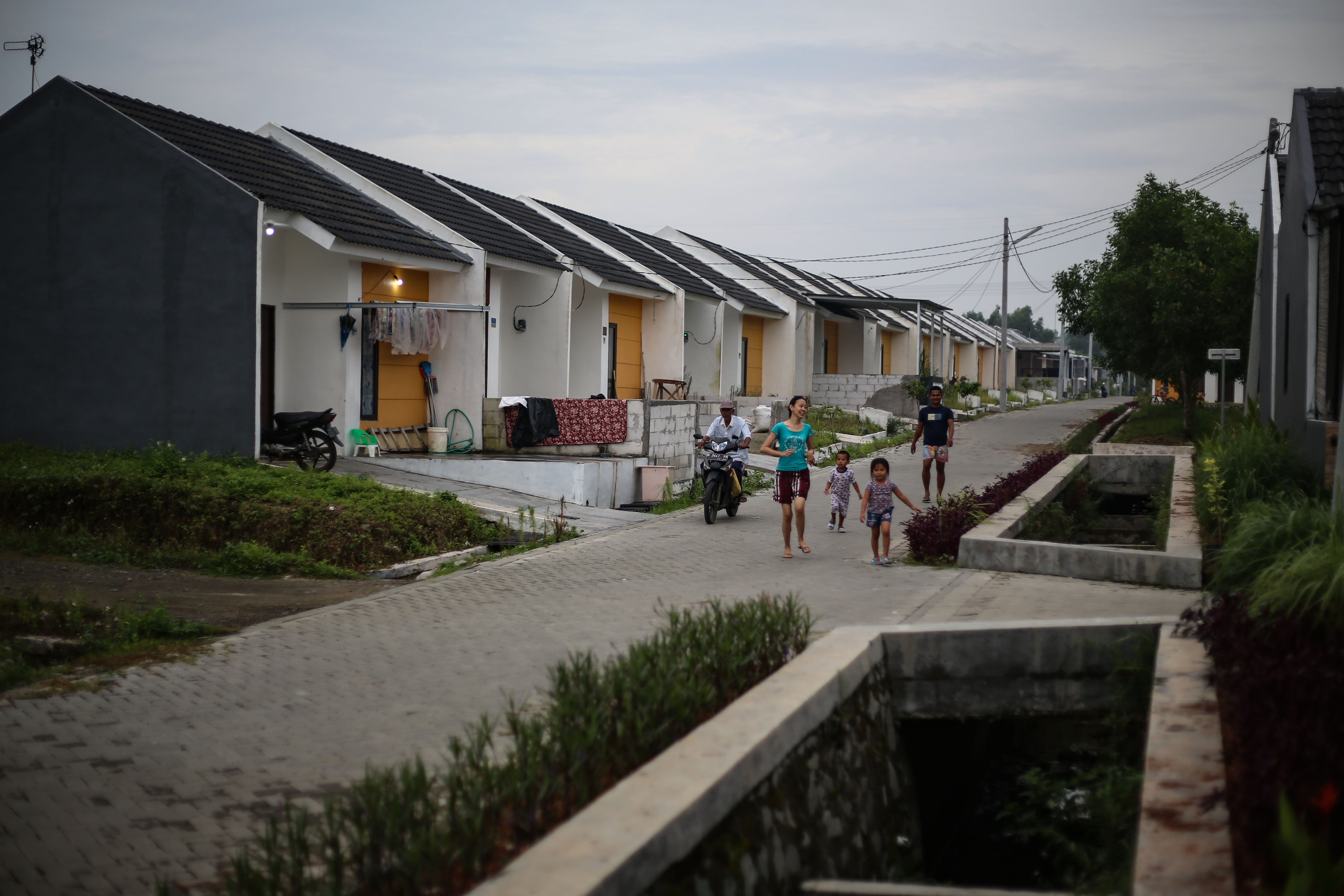  Warga melintas di depan rumah subsidi di Kawasan Maja, Lebak, Banten, Minggu (13/2/2022). 