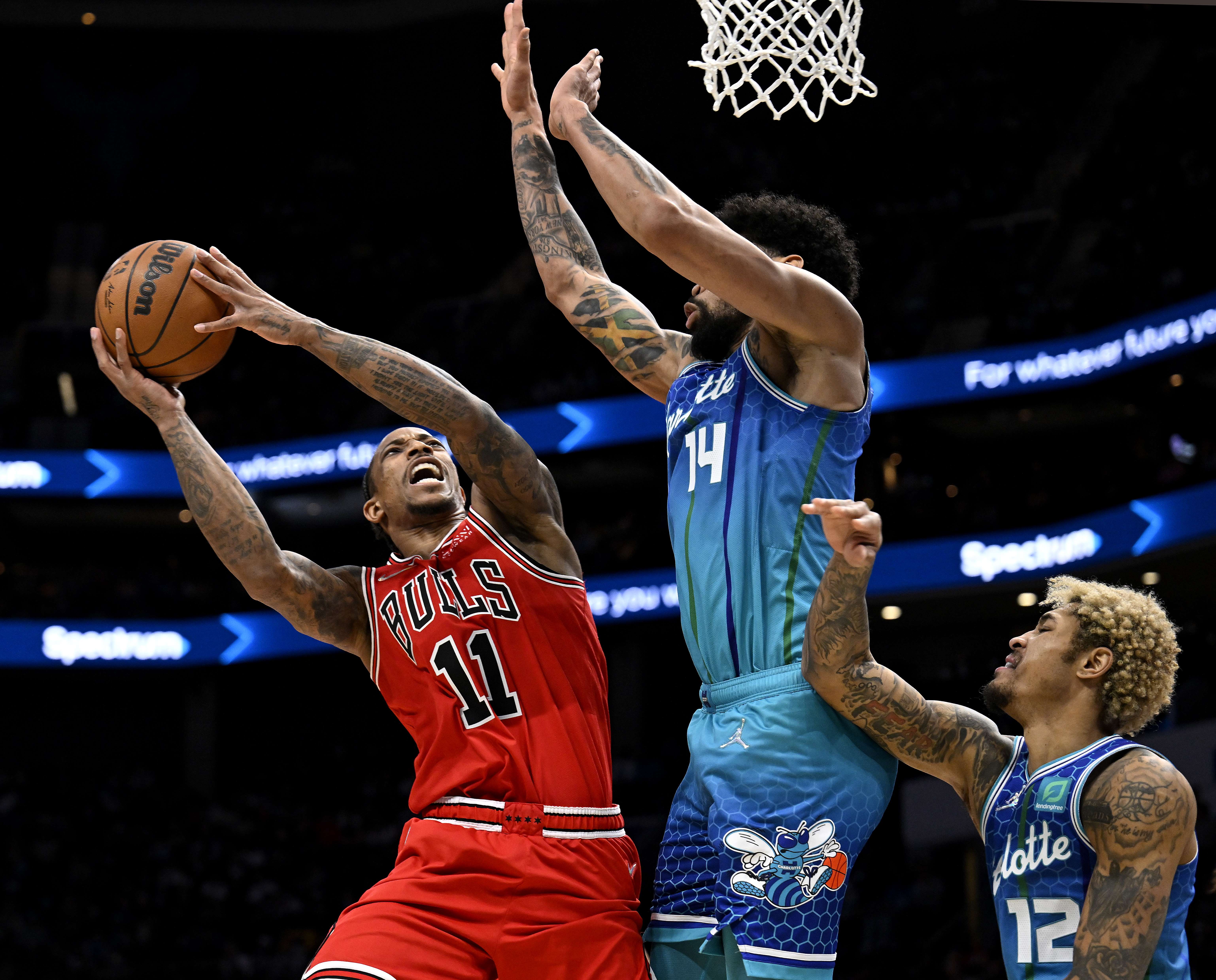 Pemain Chicago Bulls DeMar DeRozan (kiri) berusaha melepaskan tembakan saat dihadang pemain Charlotte Hornets di laga NBA.