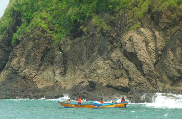 Tim SAR melakukan pencarian korban yang terseret ombak dengan menggunakan perahu di perairan Pantai Payangan Jember, Jawa Timur.