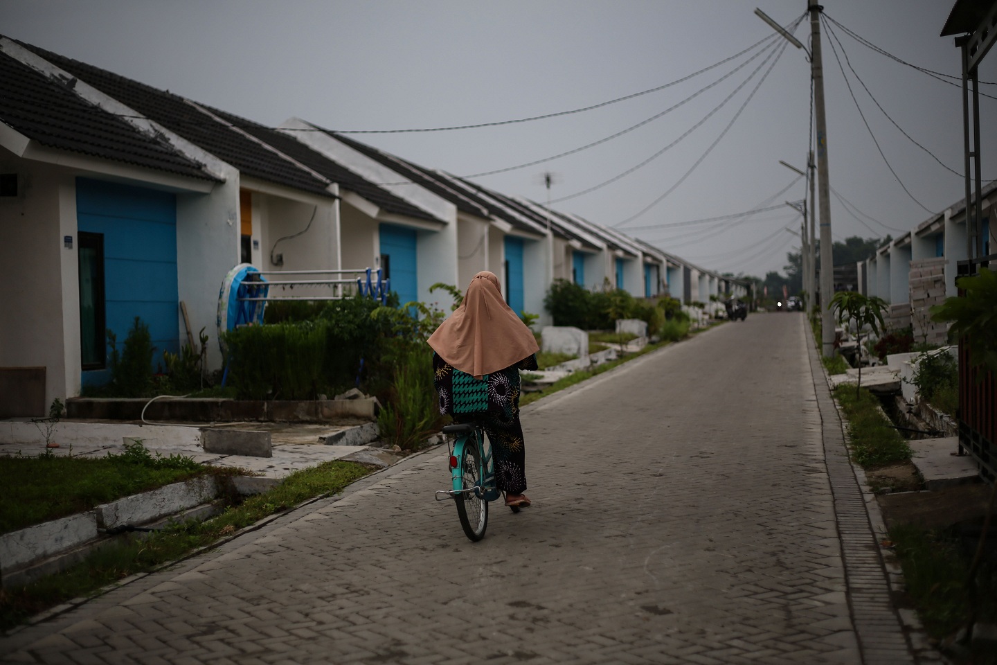 Warga melintas di depan rumah subsidi di Kawasan Maja, Lebak, Banten, Minggu (13/2)