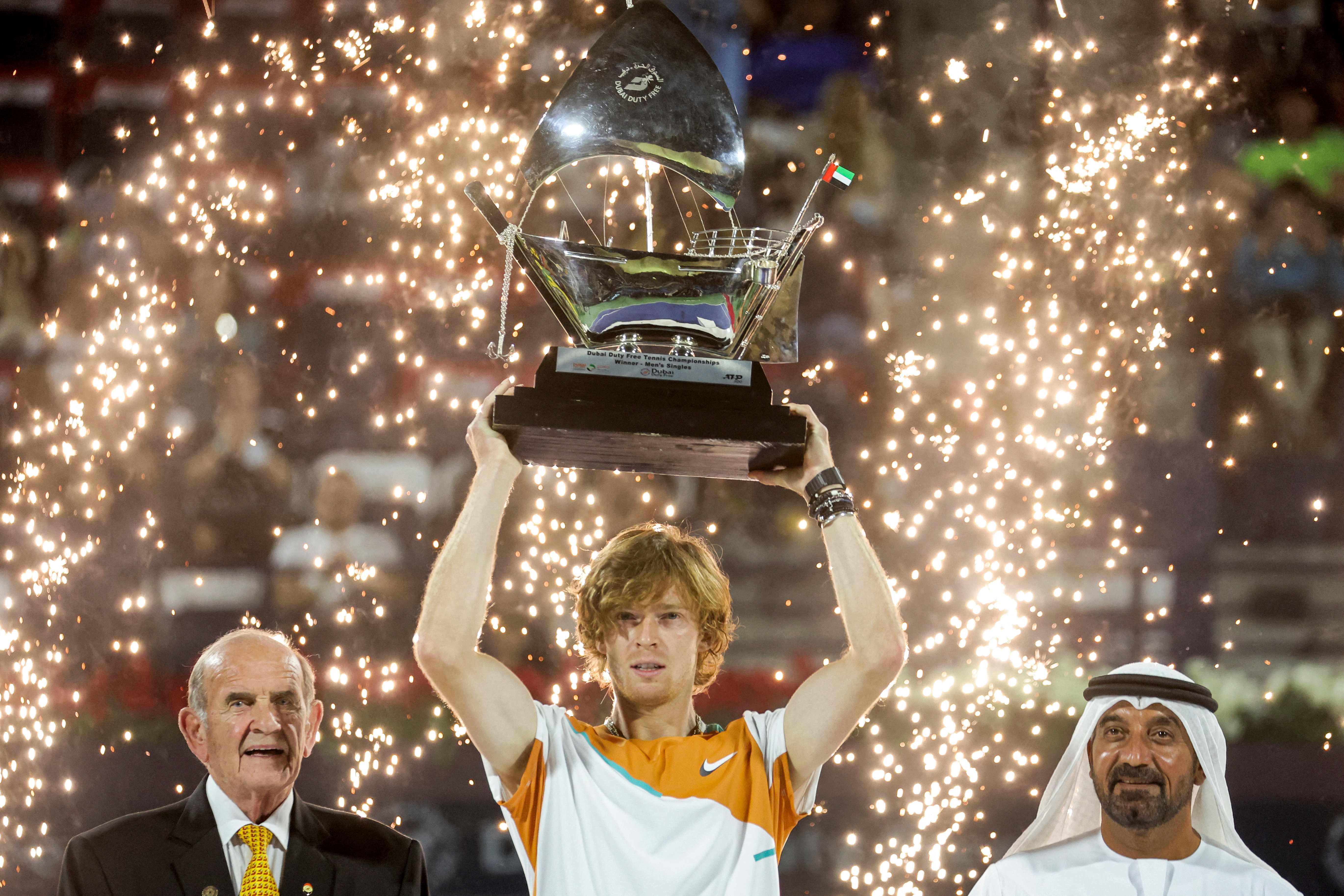 Petenis Rusia Andrey Rublev mengangkat trofi yang dimenangkannya di Dubai.