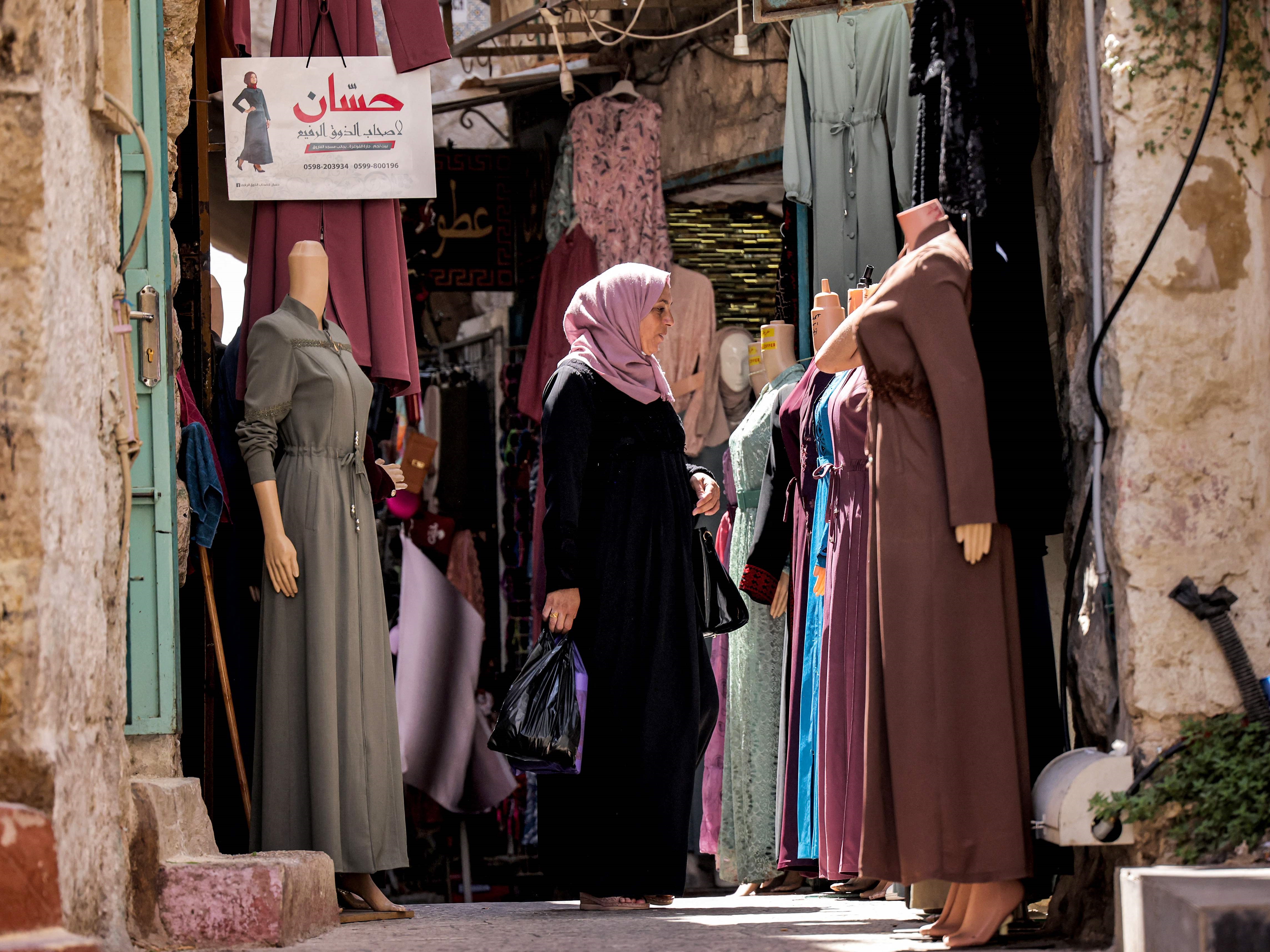 Seorang wanita berbelanja gaun di pasar di kota tua Betlehem di Tepi Barat yang diduduki Israel pada 14 September 2021.