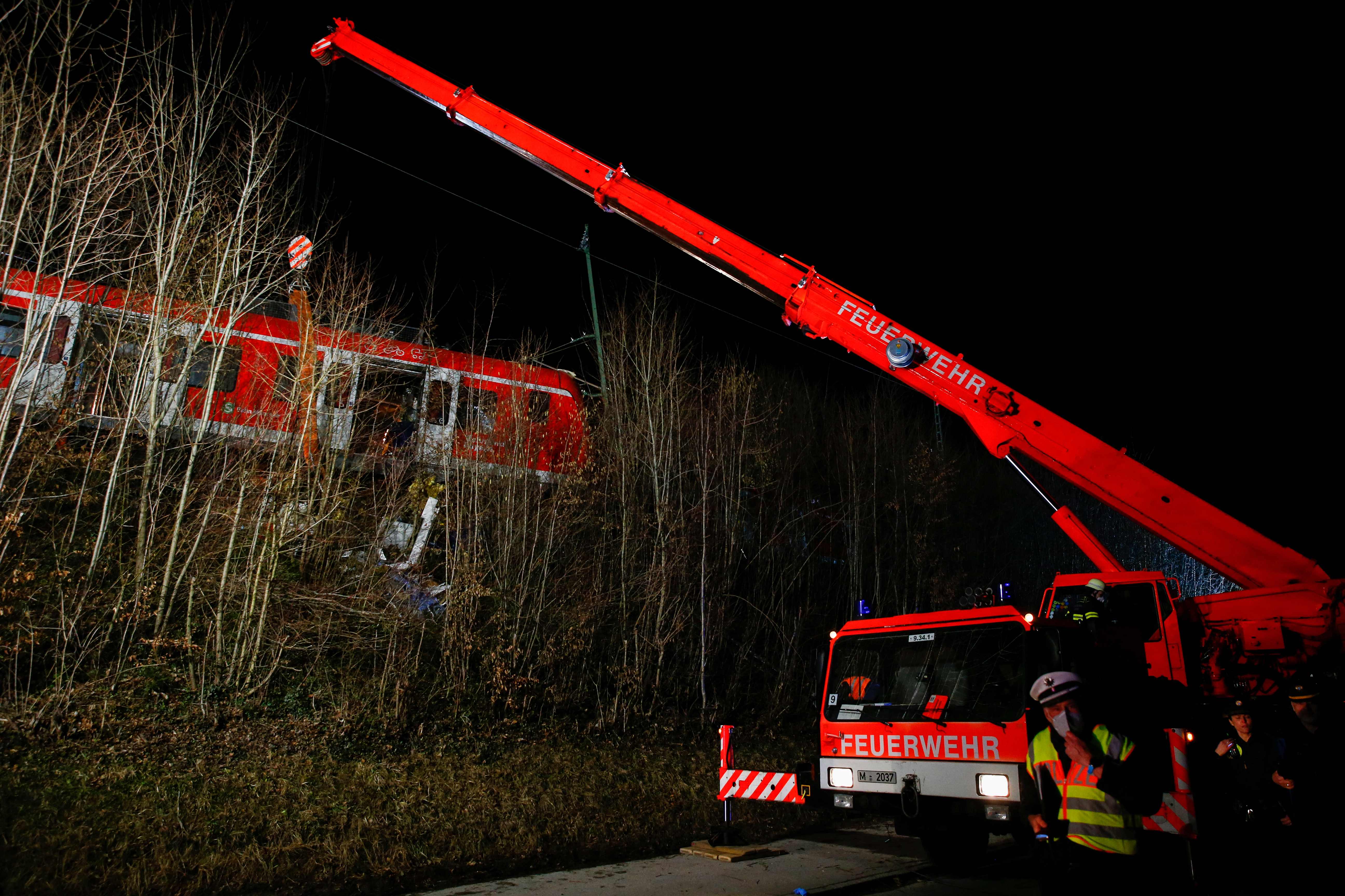 Petugas berusaha mengevakuasi gerbong kereta komuter yang mengalami kecelakaan di dekat Muenchen, Jerman.