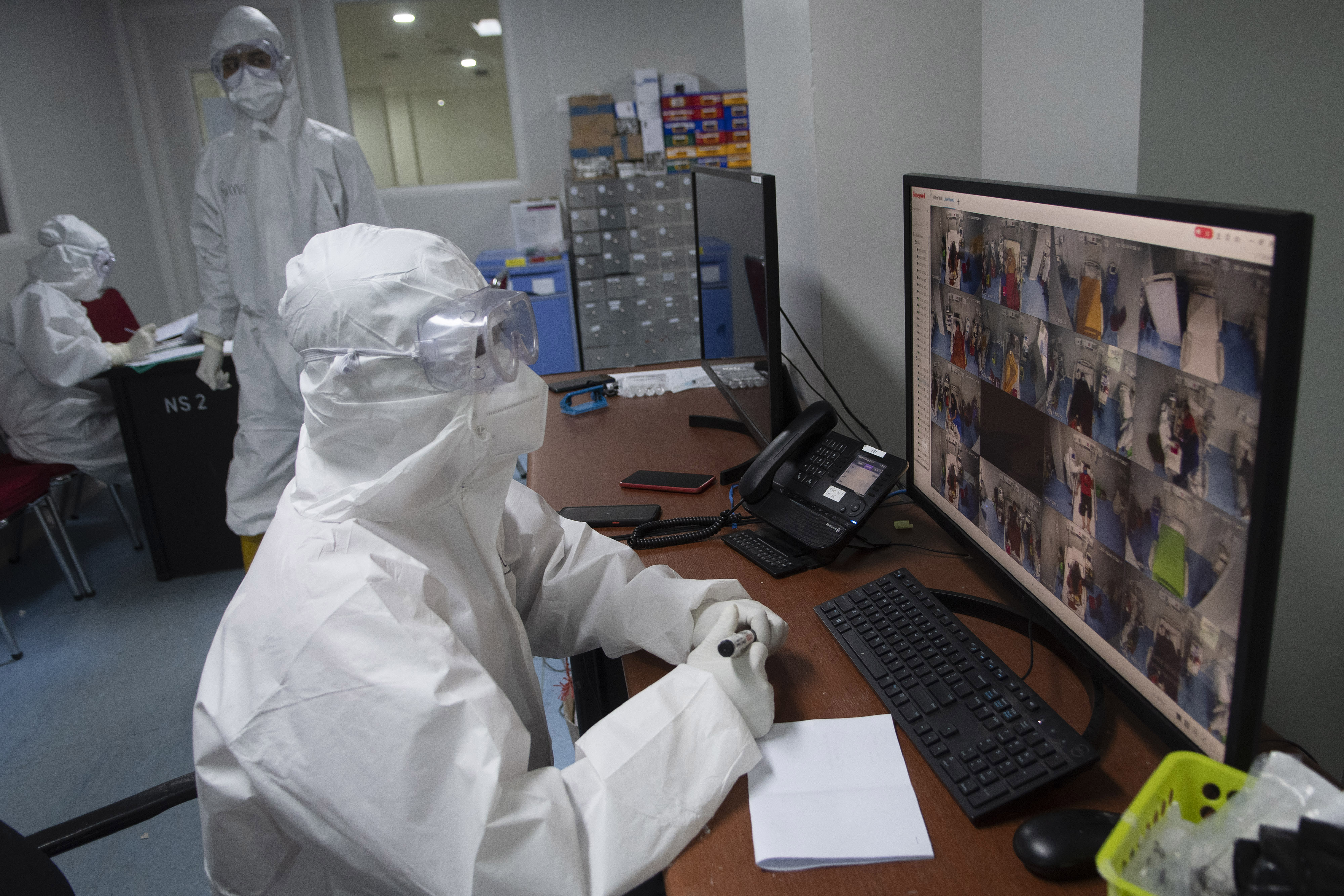 Tenaga medis mengamati monitor kamera CCTV  di ruang perawatan pasien covid-19 di RSDC Wisma Atlet, Kemayoran, Jakarta.