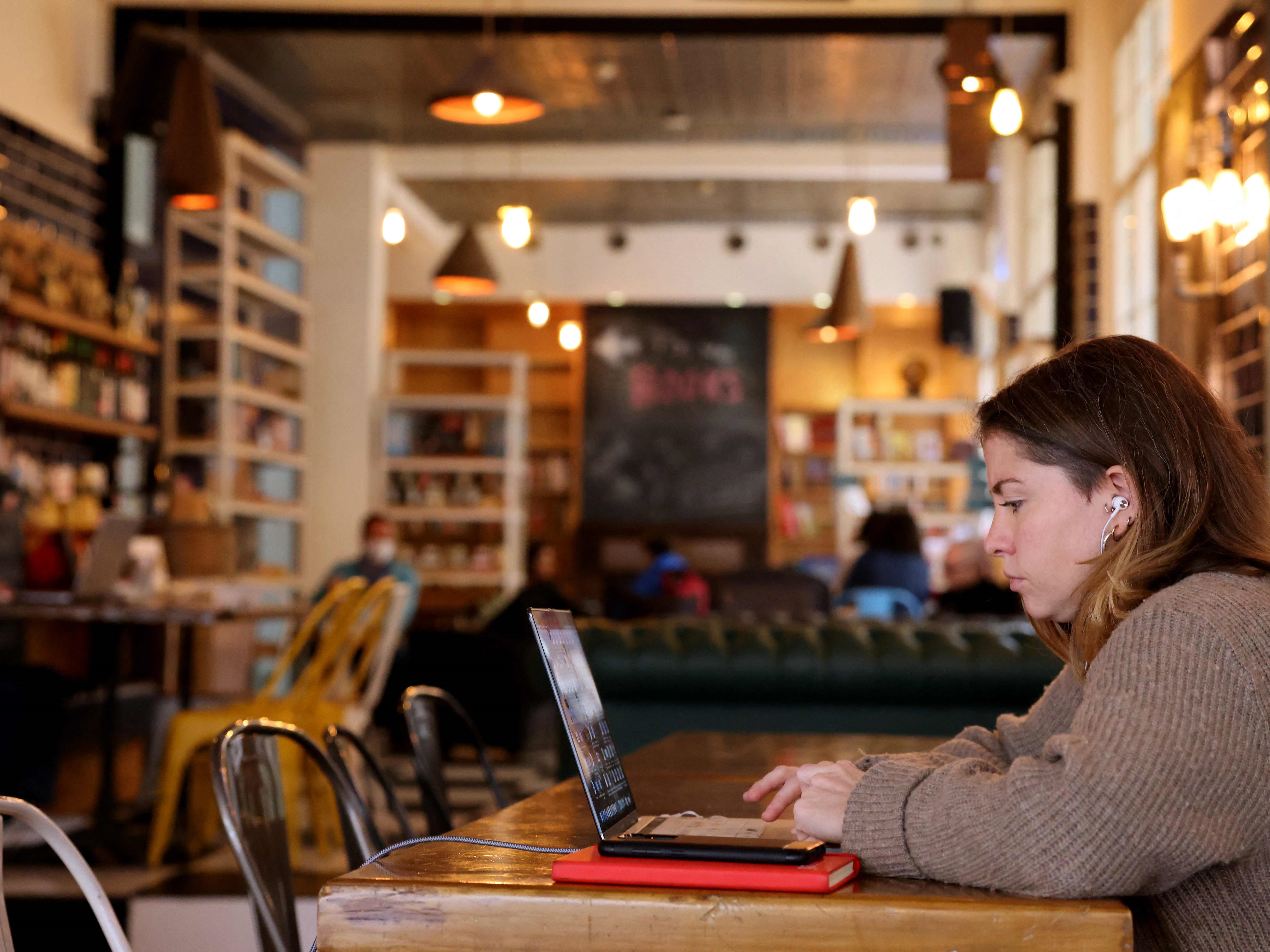 Seorang wanita duduk dengan laptopnya di kafe, Beirut, pada 14 Januari 2022.