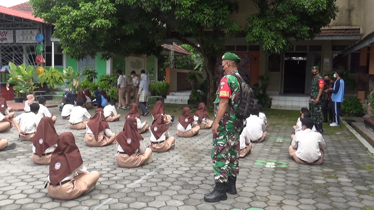 TNI dari Koramil Kalasan melakukan penyemprotan disinfektan ke sekolah-sekolah TNI sosialisasi dan mengajak siswa selalu prokes