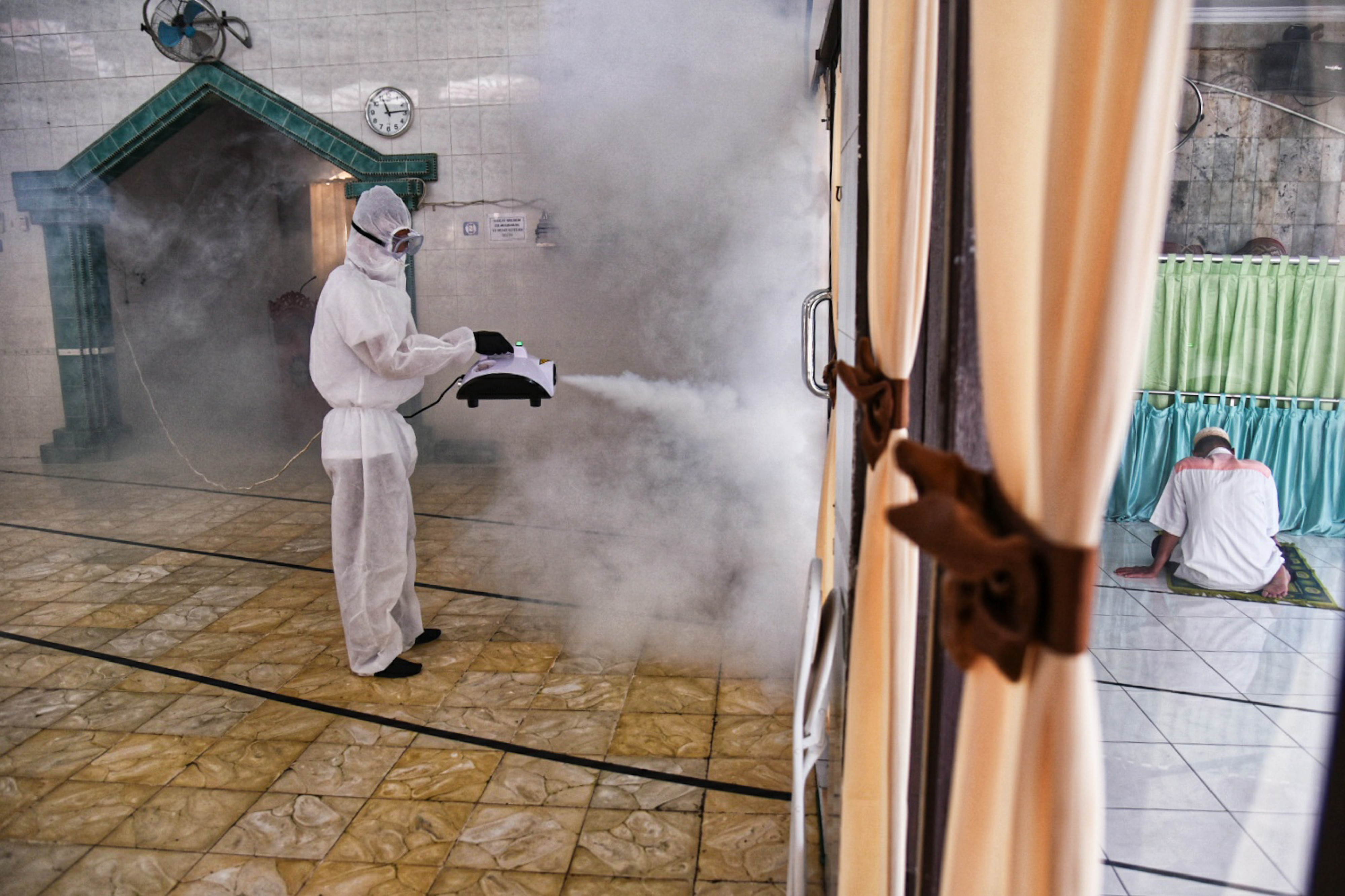 Petugas melakukan penyemprotan disinfektan di masjid wilayan Medan, Sumatra Utara.