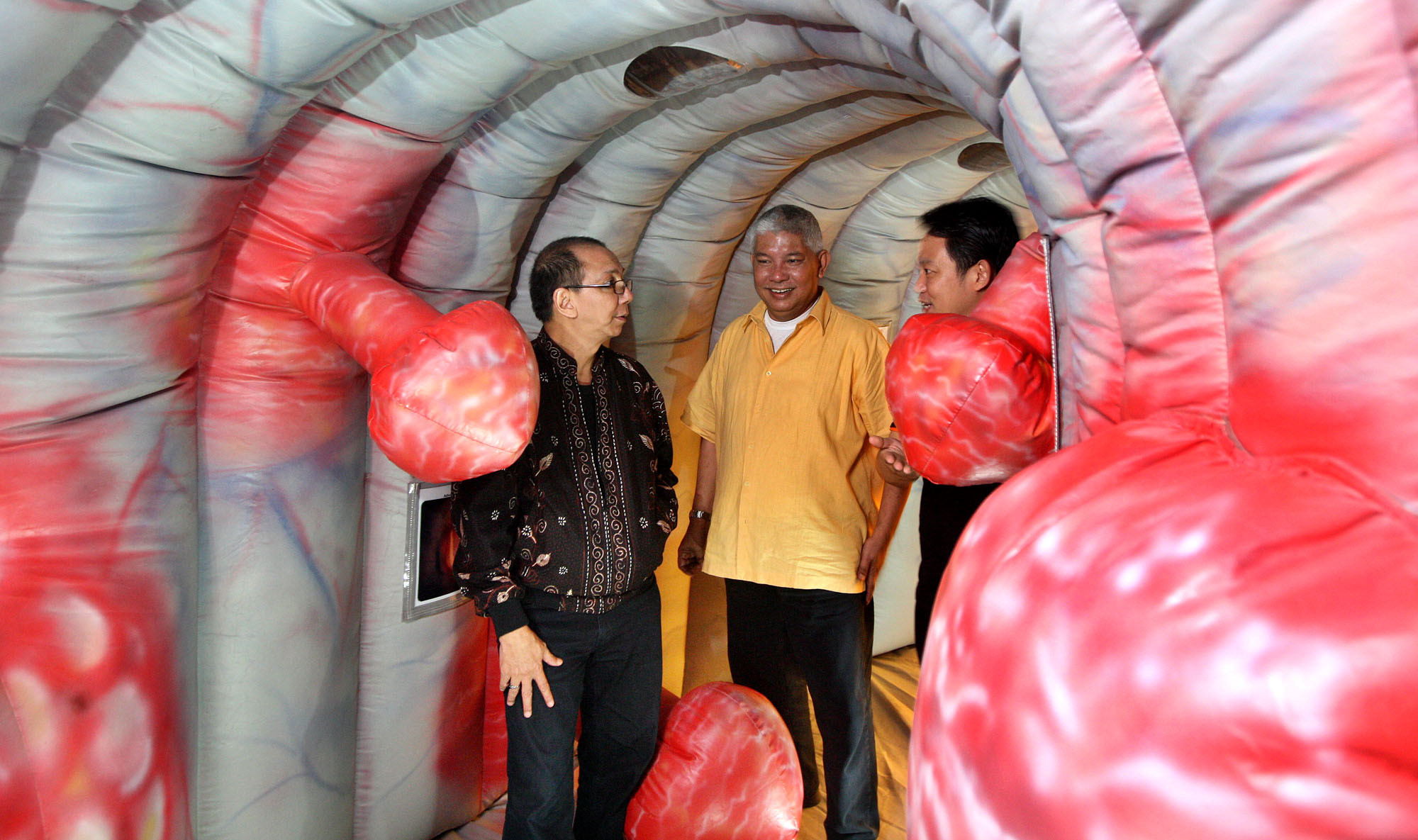 Tiga pasien kanker usus besar memasuki replika usus yang terbuat dari kantong udara di Hotel Sahid, Jakarta Selatan.