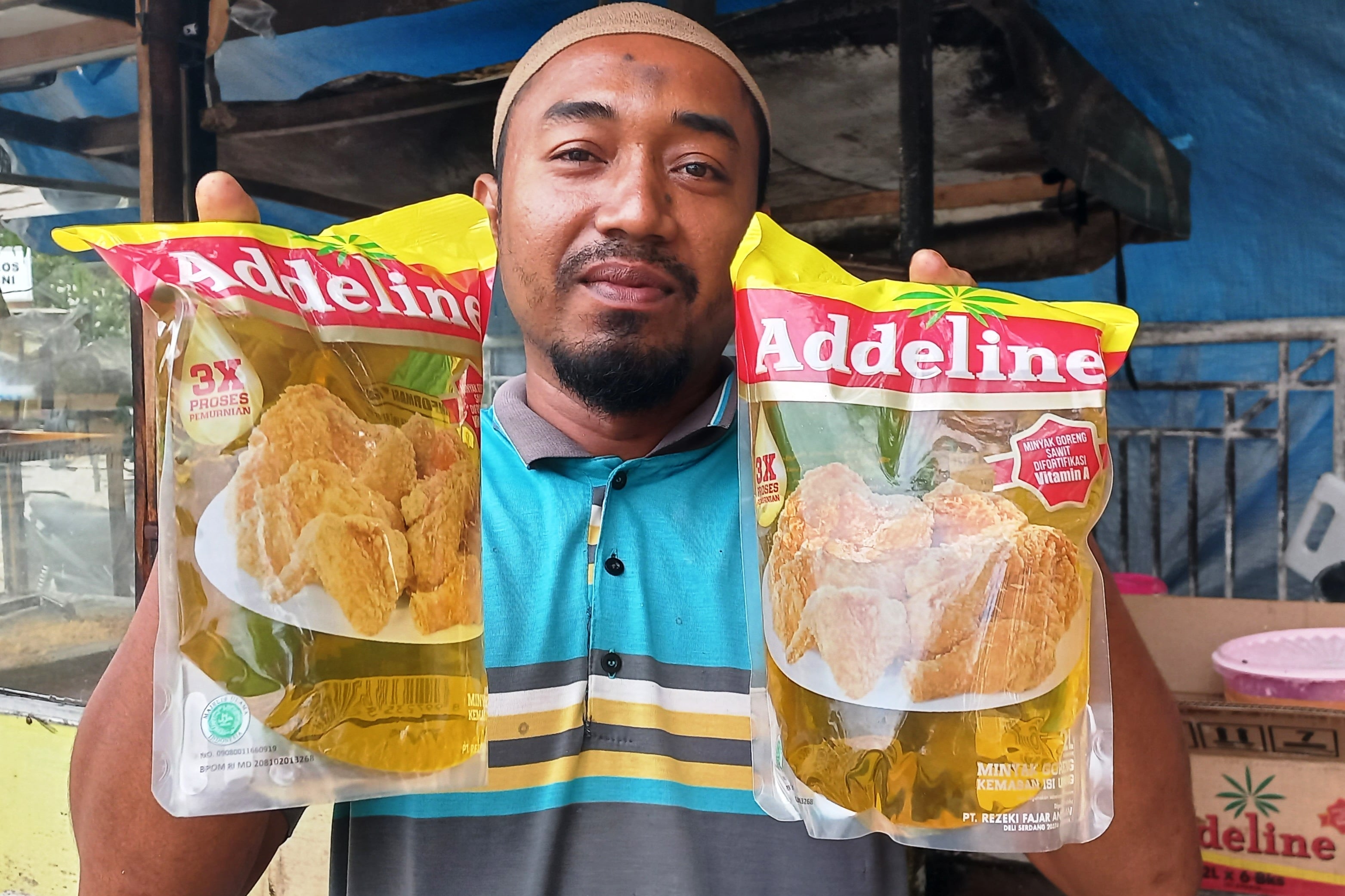 Mauluddin, sedang memperlihatkan minyak goreng kemasan yang dia beli dengan harga mahal, beberapa waktu lalu. 
