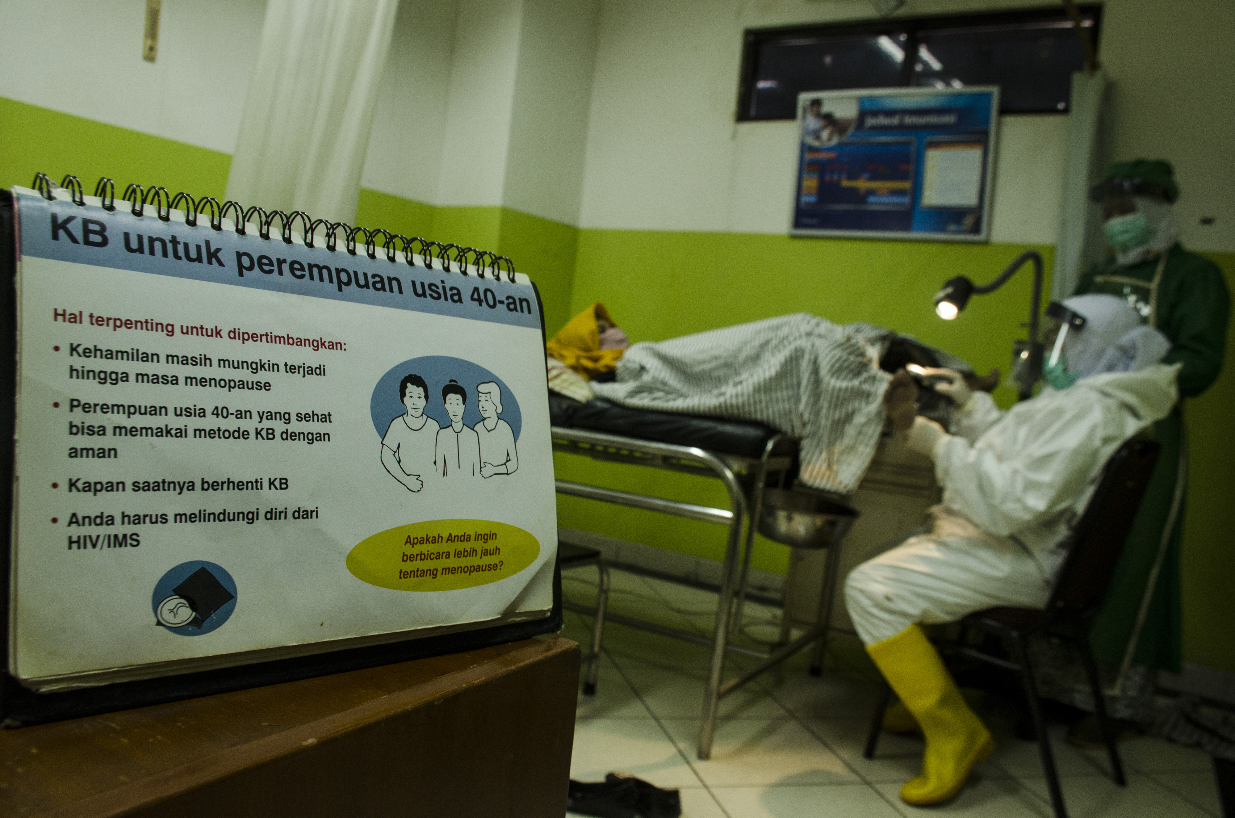 Seorang bidan melakukan pelayanan akseptor KB dengan protokol kesehatan vovid-19 di Klinik Pratama Edelweiss, Bandung, Jawa Barat.