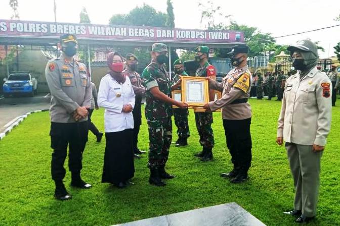 Dandim 0713/ Brebes Letkol Mohamad Haikal Sofyan menerima  piagam penghargaa yang diserahkan personel Polres Brebes mewakili Kapolda Jateng.