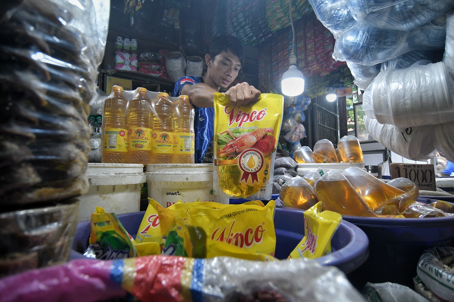 Pedagang pasar tradisional merapikan minyak goreng kemasan