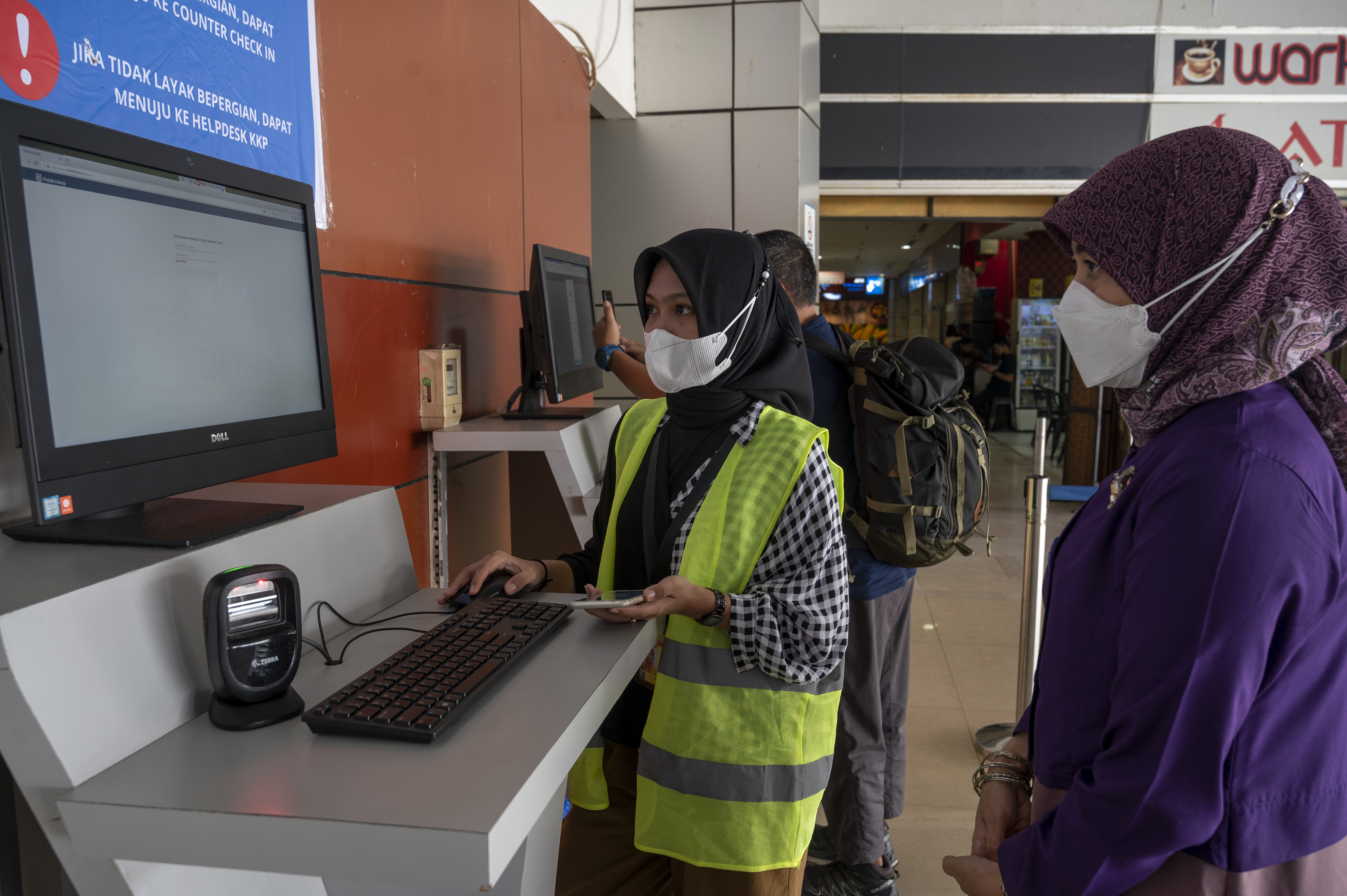 Peetugas memandu calon penumpang pesawat melakukan verifikasi dokumen kelayakan perjalanan