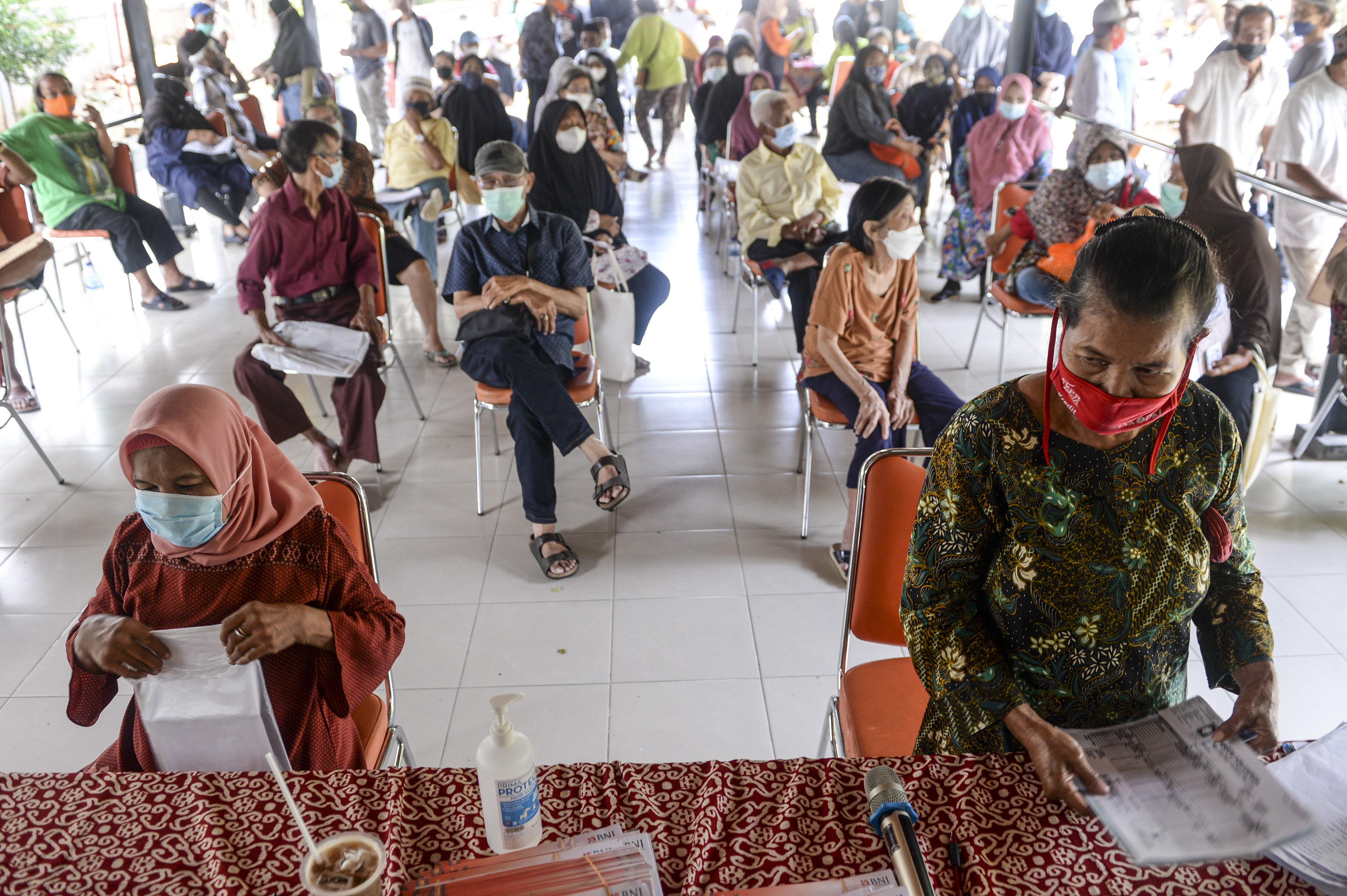 PENYALURAN BANSOS: Sejumlah warga lanjut usia antre saat penyaluran bantuan sosial PKH dan BPNT di Jakarta, Selasa (4/1/2022).