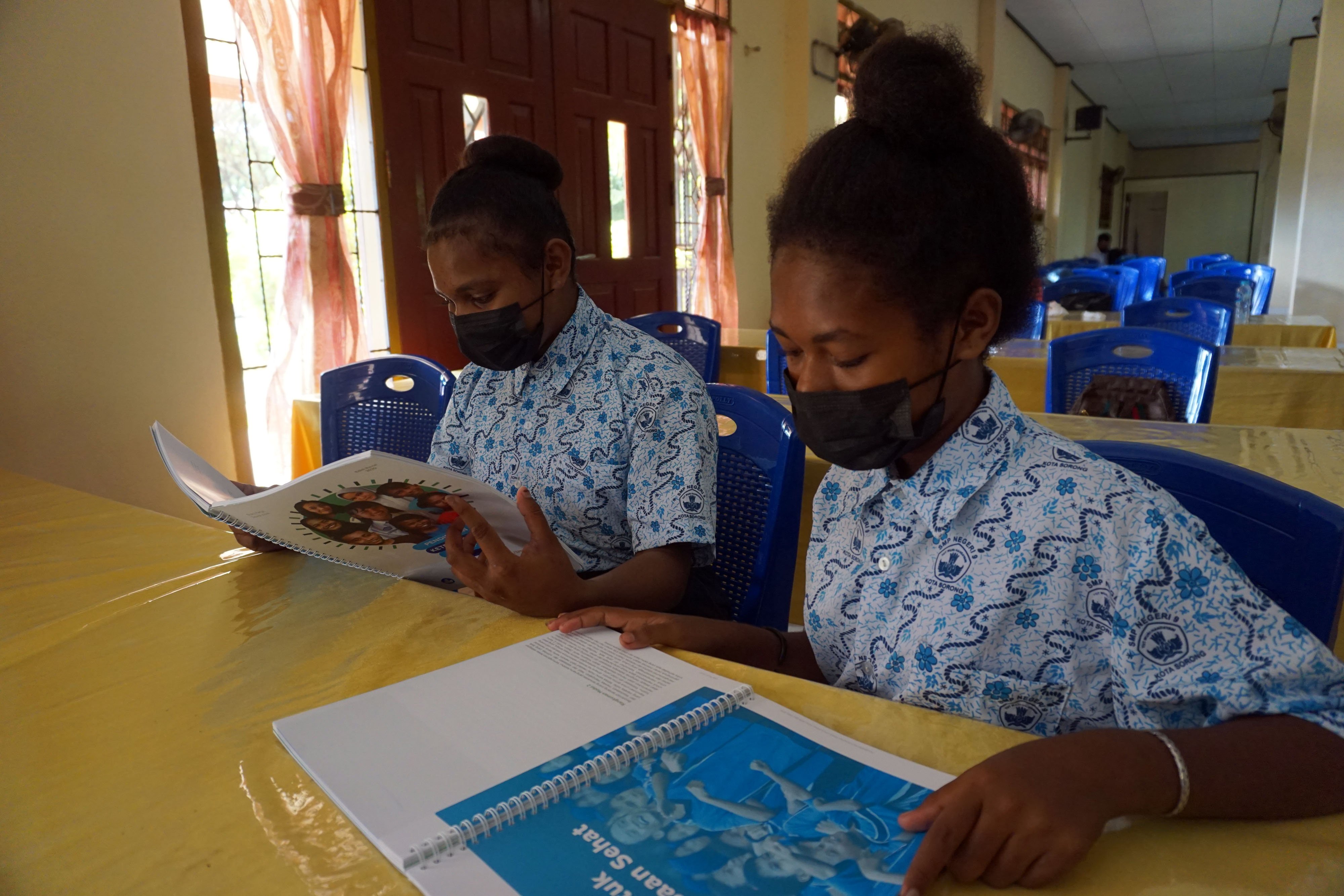  Dua pelajar membaca modul Pendidikan Keterampilan Hidup di SMP Negeri 9 Kota Sorong, Papua Barat.