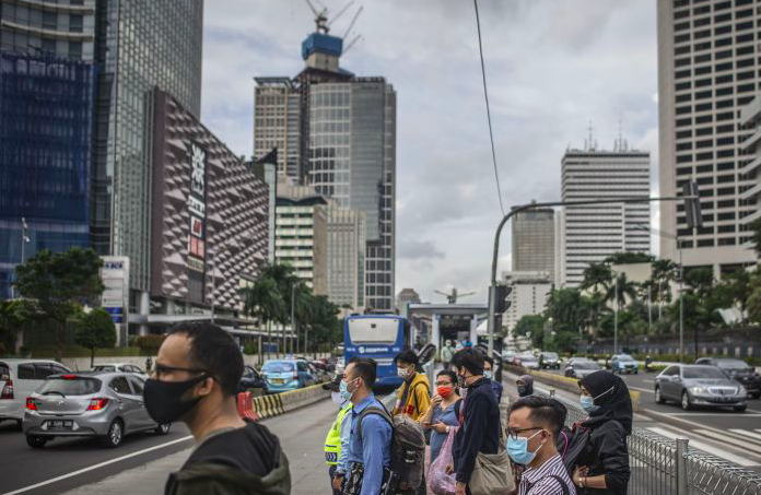 Warga bersiap menyeberang Jalan Jenderal Sudirman di Jakarta, Kamis (17/12/2020)