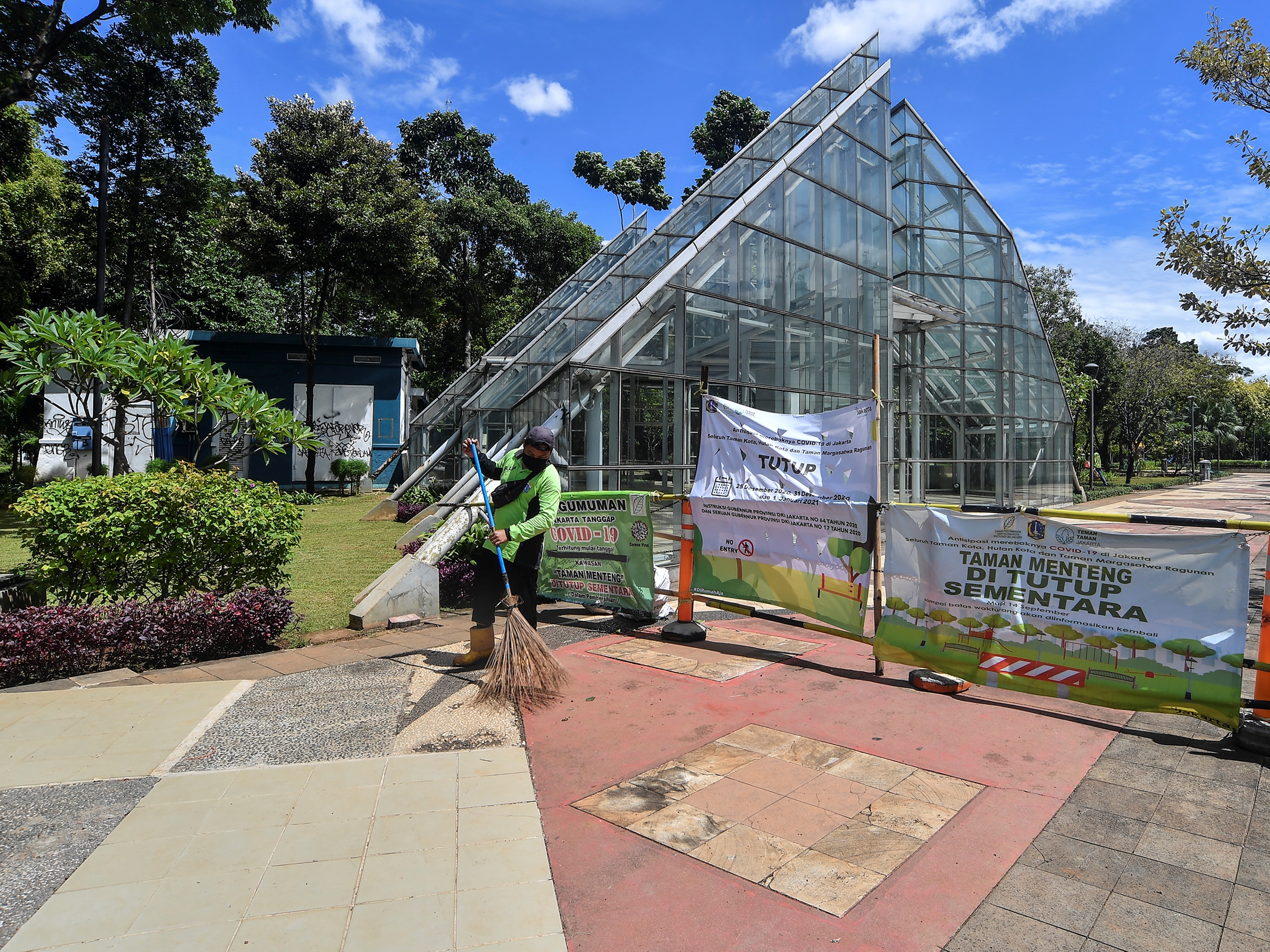 Petugas Dinas Pertamanan dan Pemakaman menyapu di kawasan Taman Menteng, Jakarta, Jumat (25/12/2020). 
