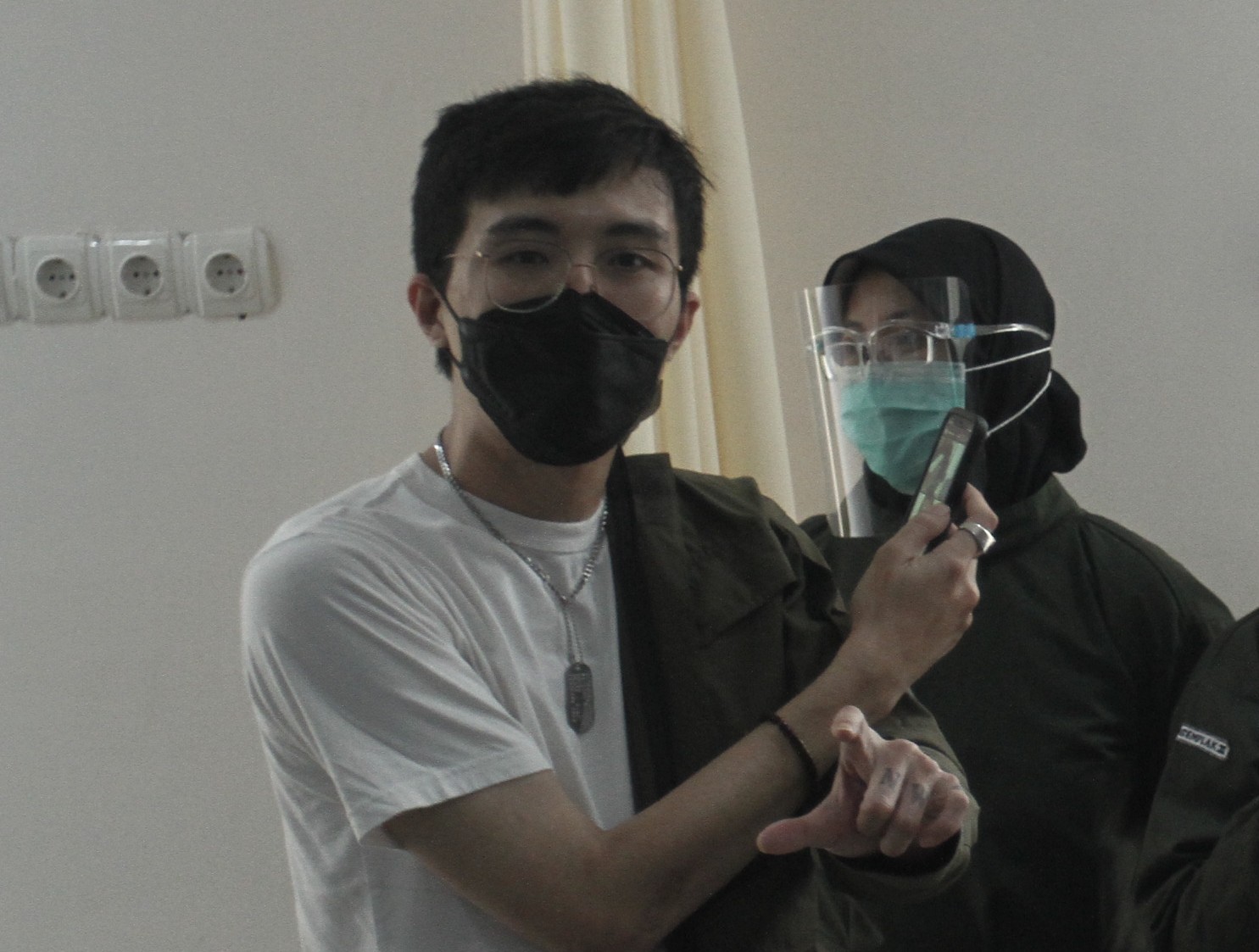 Dokter Tirta Mandira Hudhi (kiri) melihat kemasan vaksin Covid-19 saat ikuti vaksinasi di Puskesmas Ngemplak 2, Sleman, DI Yogyakarta.