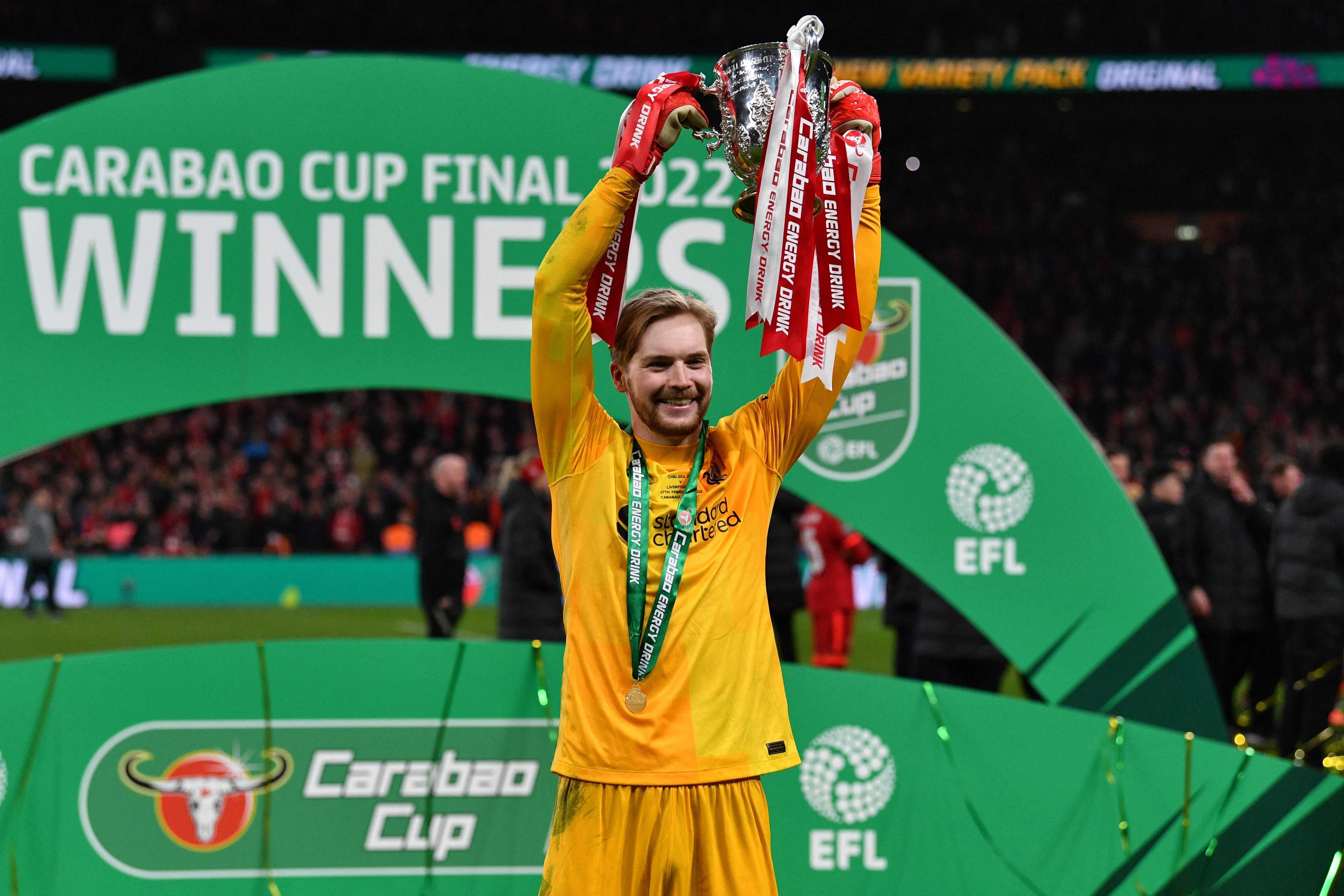 Penjaga gawang Liverpool Caoimhin Kelleher mengangkat trofi Piala Liga