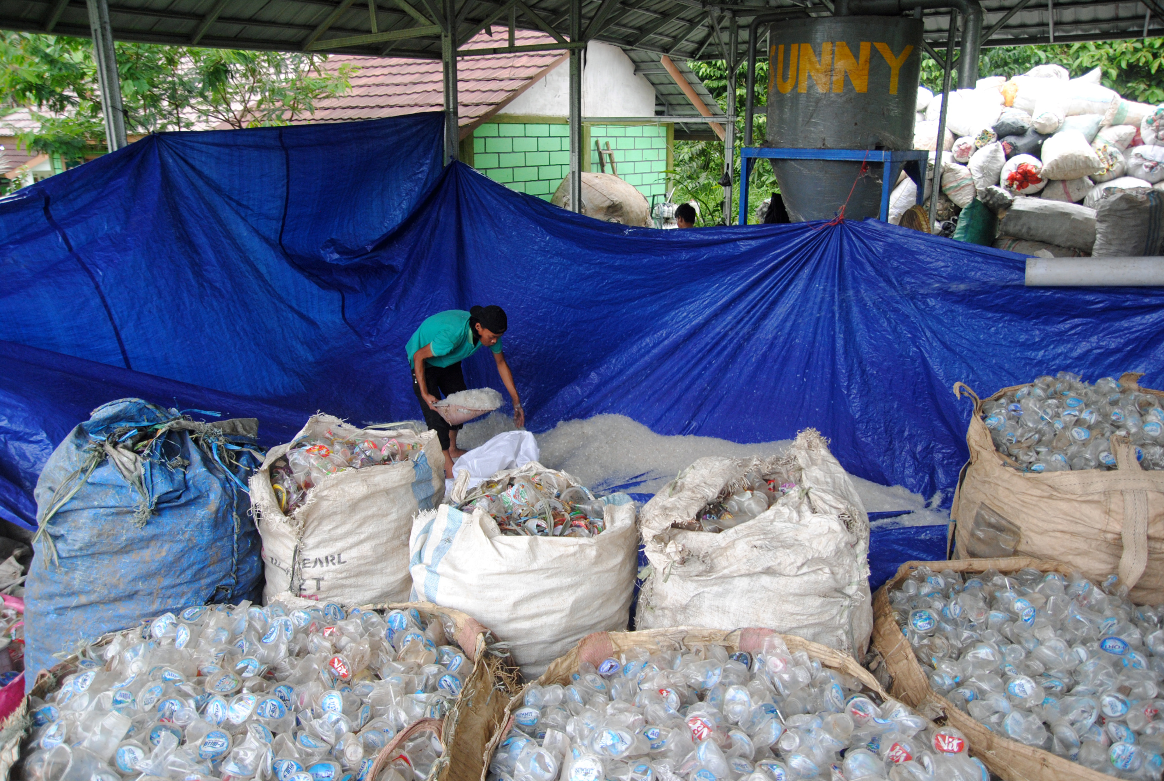 Pekerja memasukan sampah gelas plastik yang telah dicacah ke dalam karung di Rumah Pengolahan Sampah Citra (RPSC), Desa Jogjogan, Cisarua, 