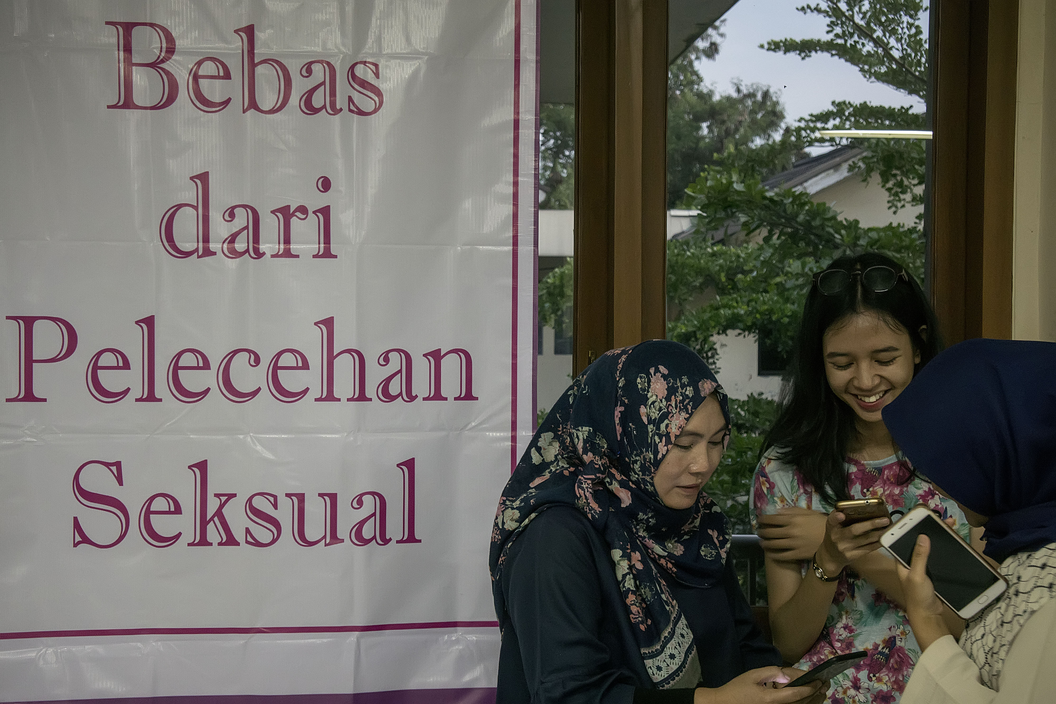 Ilustrasi sejumlah mahasiswi berdiri di dekat poster kampanye stop kekerasan seksual.