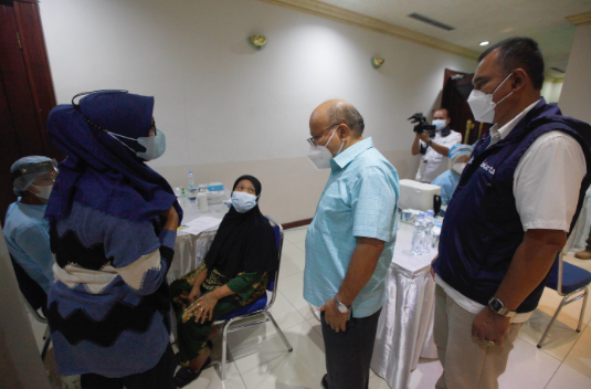 Vice President News and Media, Media Group Network, Don Bosco Selamun berbincang dengan warga sekitar yang mengikuti vaksinasi, Minggu(20/2)