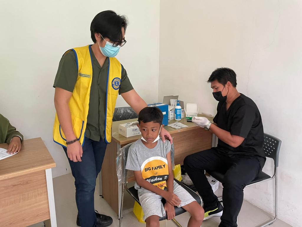 Seorang anak tengah bersiap divaksin.