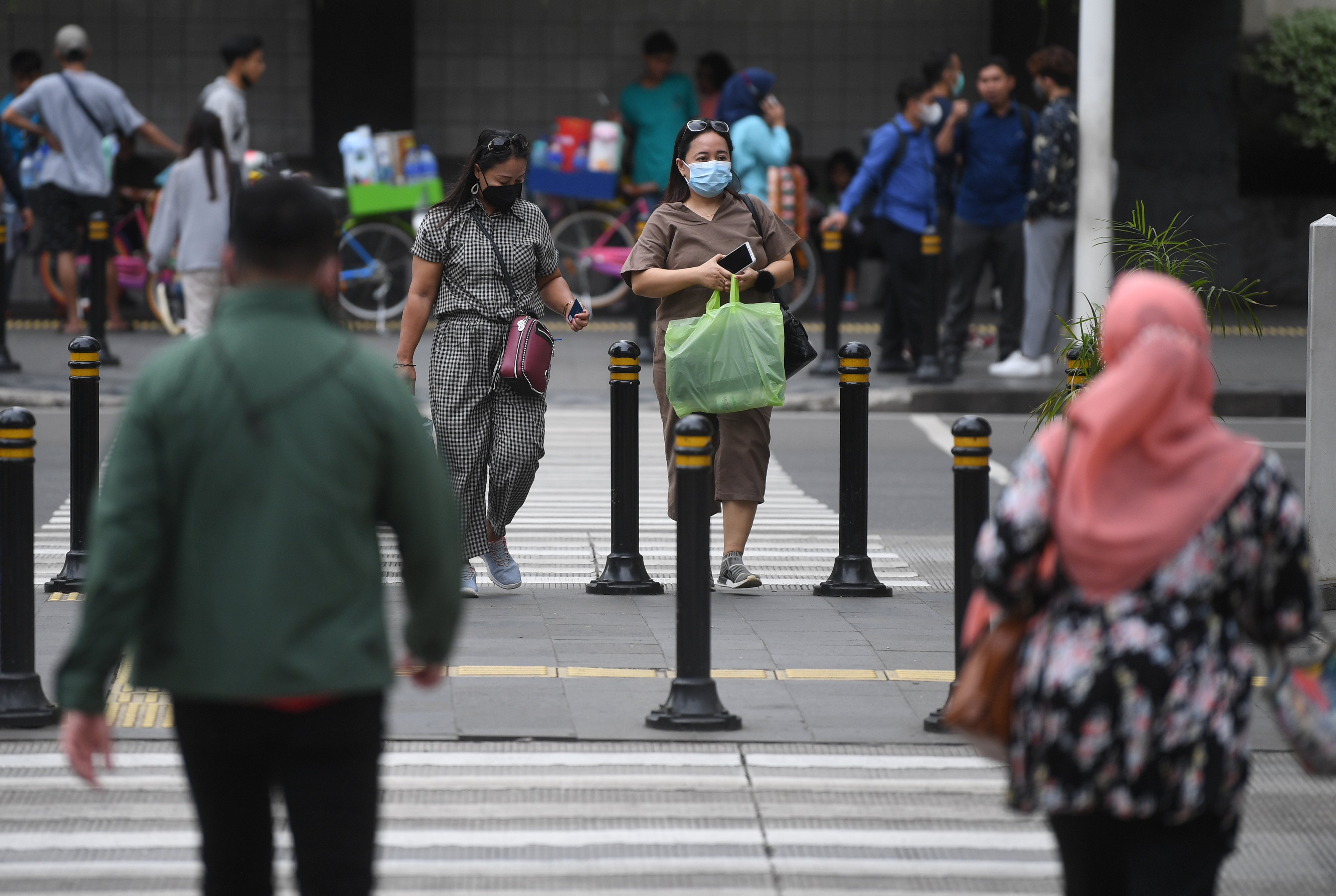 Warga berjalan di kawasan Sudirman, Jakarta.