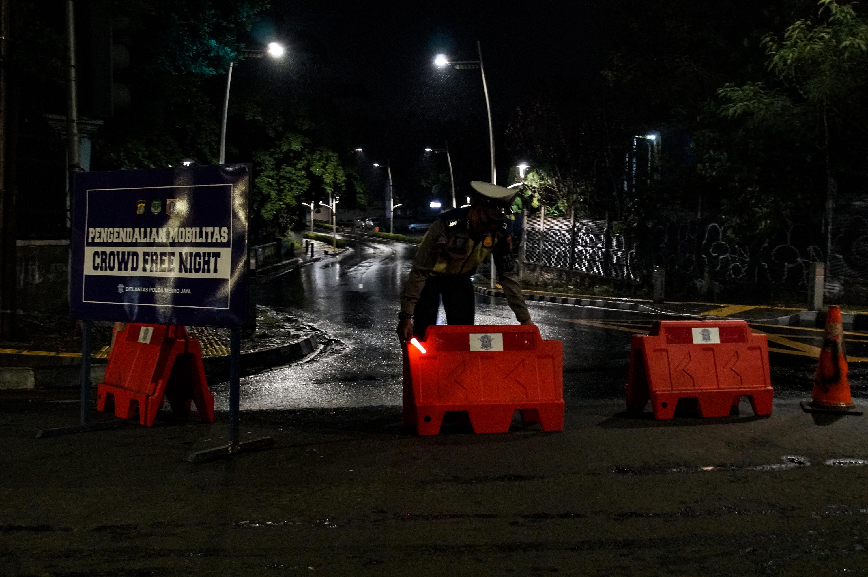 Petugas menutup akses jalan menuju Kemang, Jakarta dalam rangka Crowd Free Night, Senin (7/2).